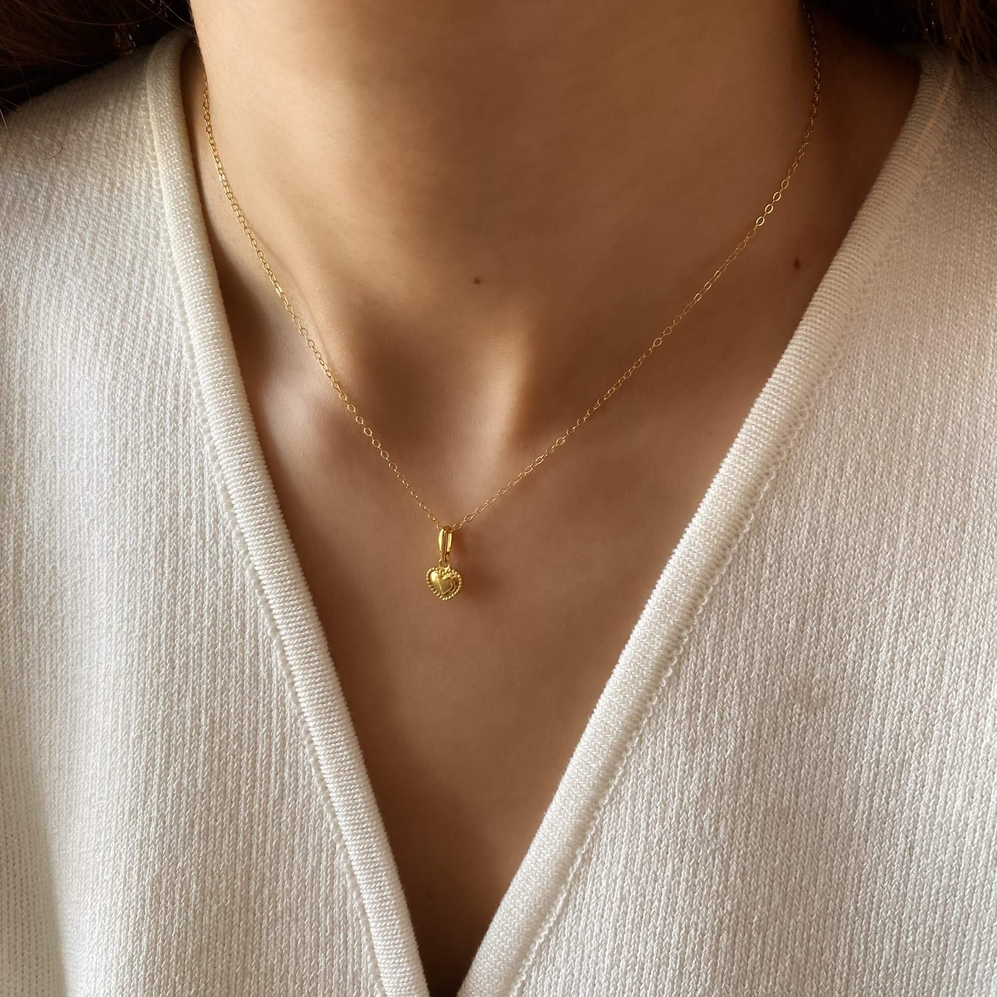 Close-up of the KahiraN 14K gold-plated tiny heart pendant necklace by Kampy Designs, showcasing its delicate heart charm and fine gold chain.