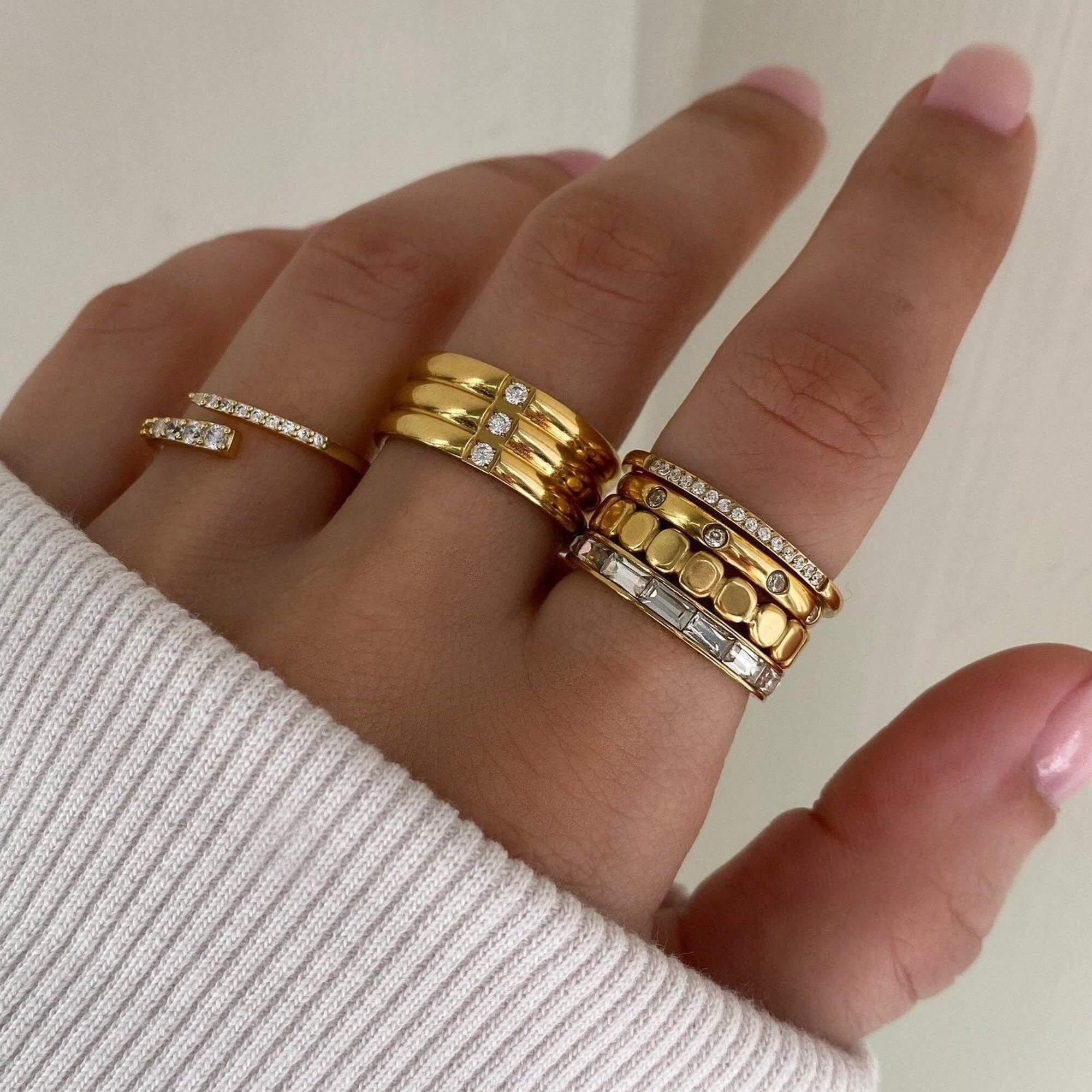 The KimikoR 14K gold-plated wrap ring by Kampy Designs, stacked with other rings for a trendy, layered jewelry look.