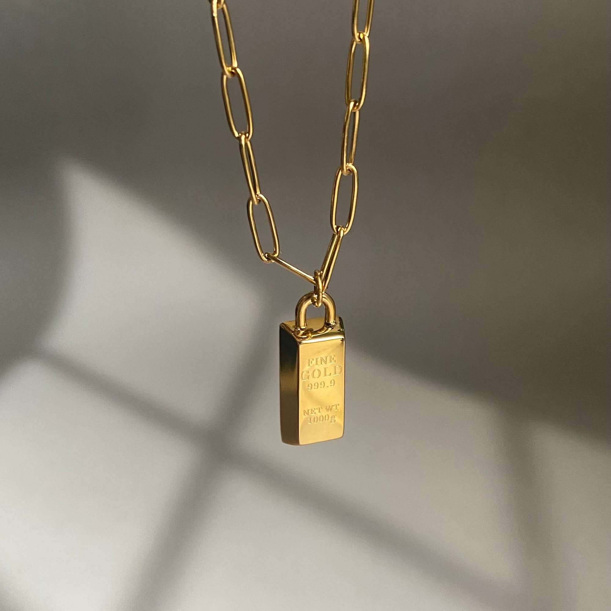 The KoldyN 18K gold bar pendant necklace by Kampy Designs, elegantly dangling to showcase its sleek and timeless aesthetic.