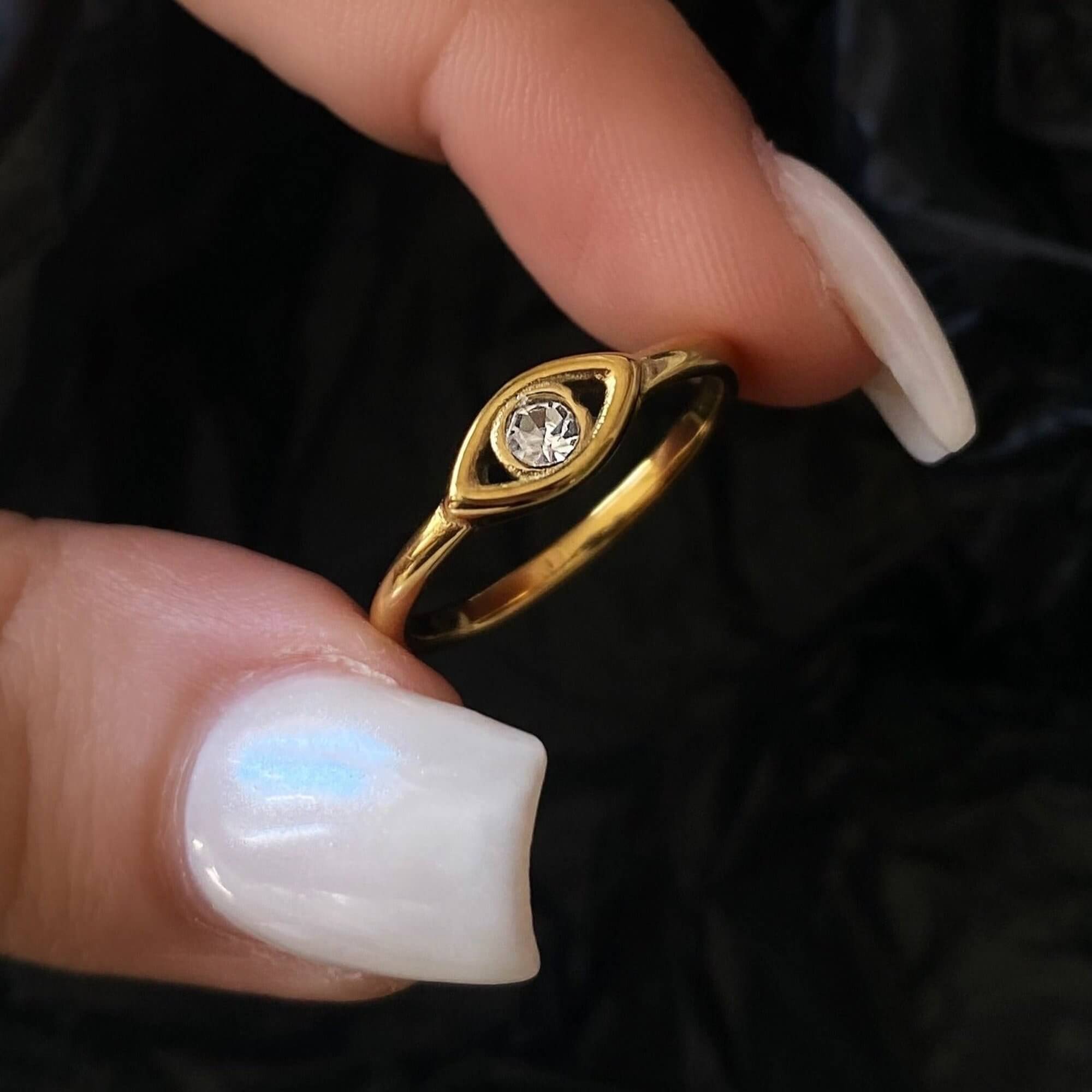 The KanakaR 18K gold-plated evil eye stone ring by Kampy Designs, held to showcase its intricate evil eye design and protective symbolism.