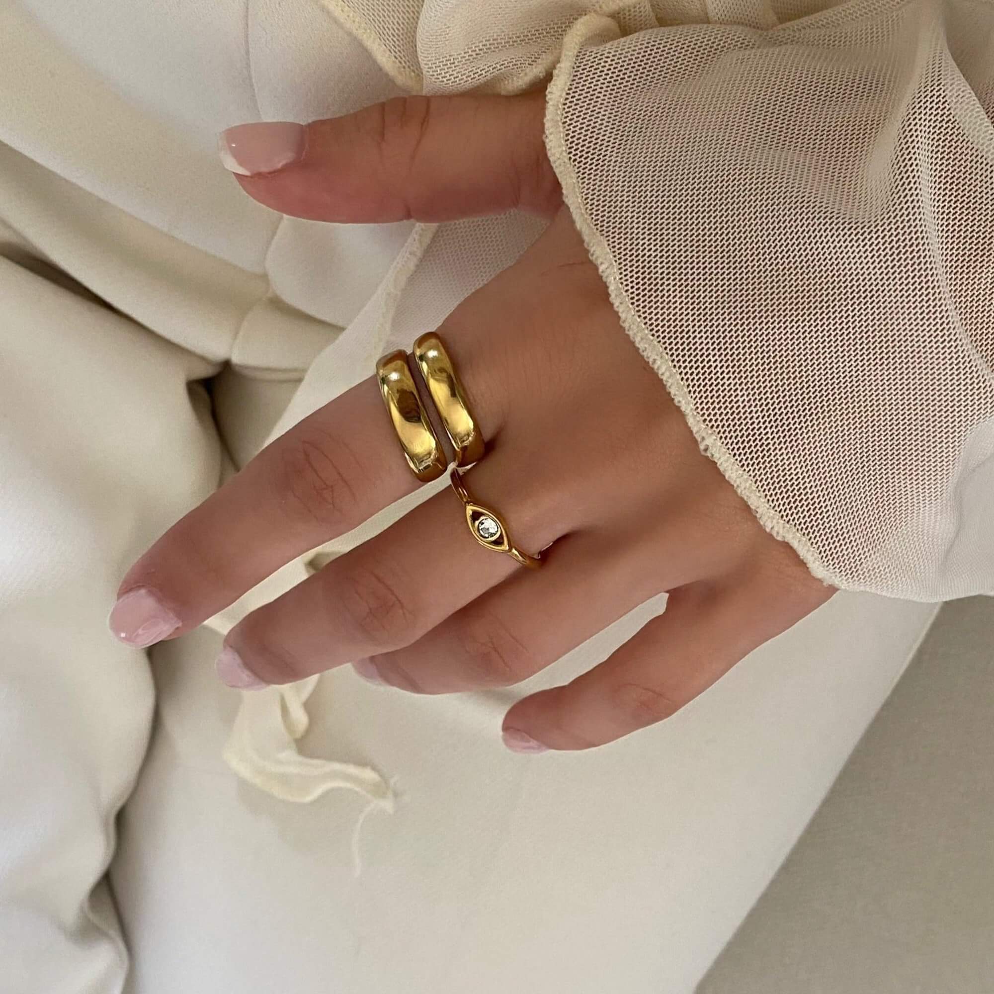 The KanakaR 18K gold-plated evil eye stone ring by Kampy Designs, styled elegantly with other jewelry to enhance its protective charm and beauty.