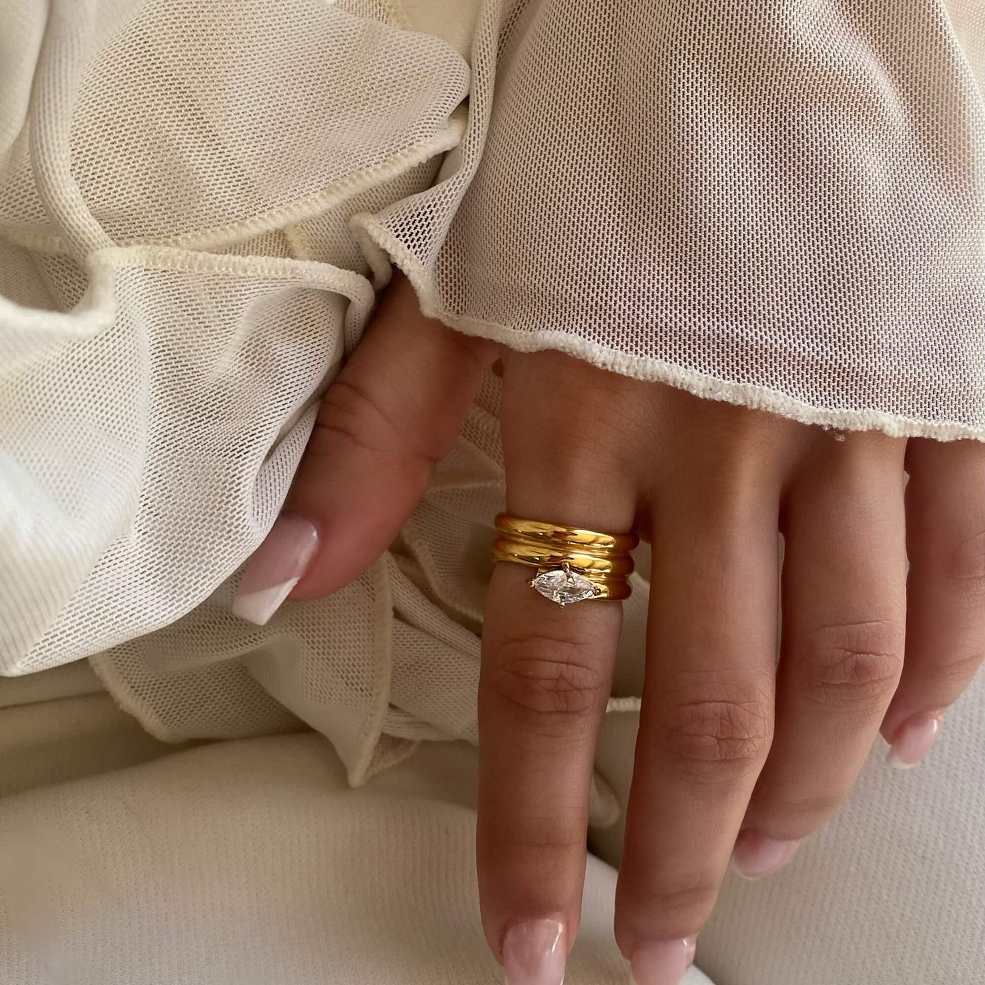 The KimchiR 18K gold-plated marquise-cut wrap ring by Kampy Designs, styled with other jewelry for a modern and sophisticated look.