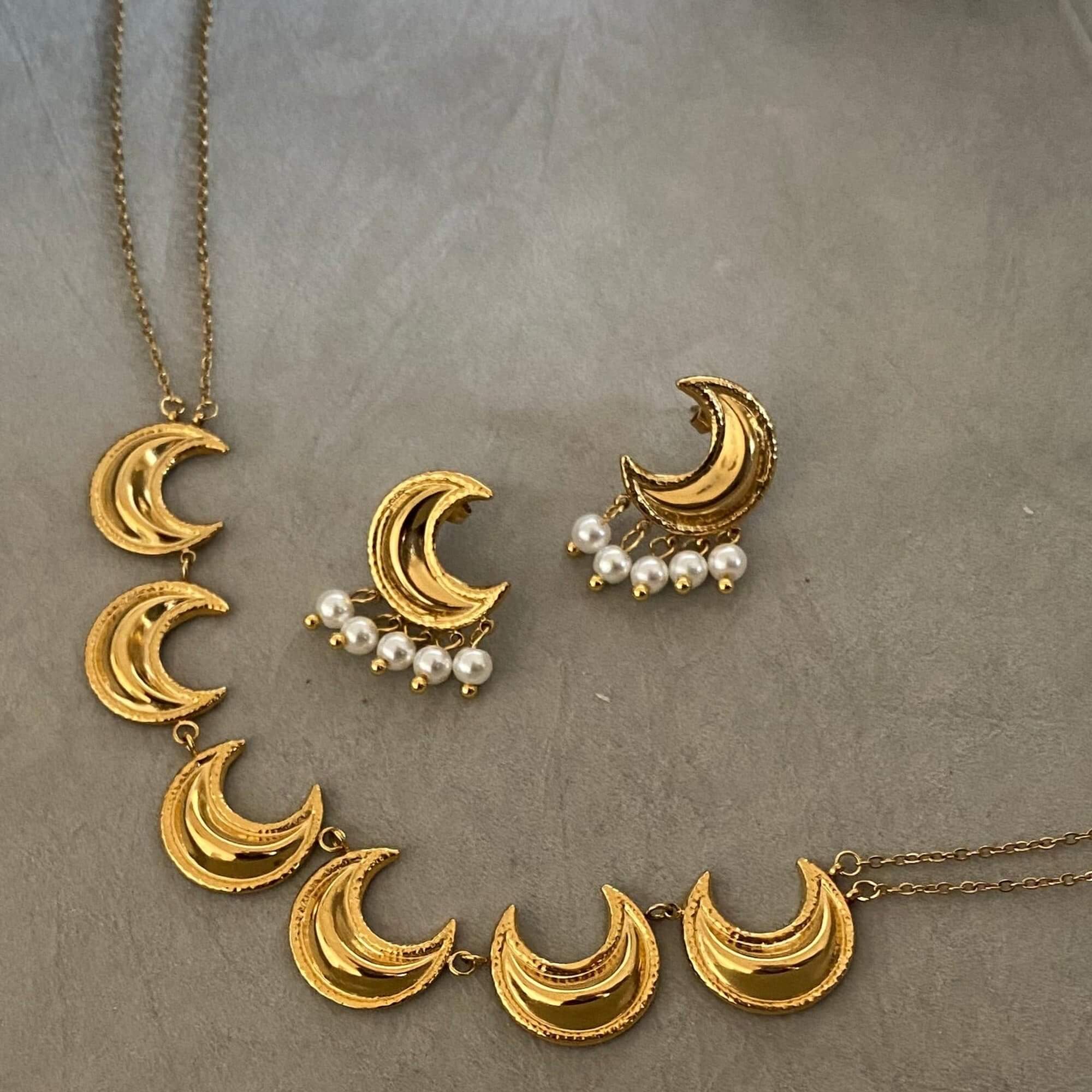 The KrescentN 18K gold-plated moon charm choker necklace by Kampy Designs, displayed as part of a layered set for a celestial-inspired jewelry look.