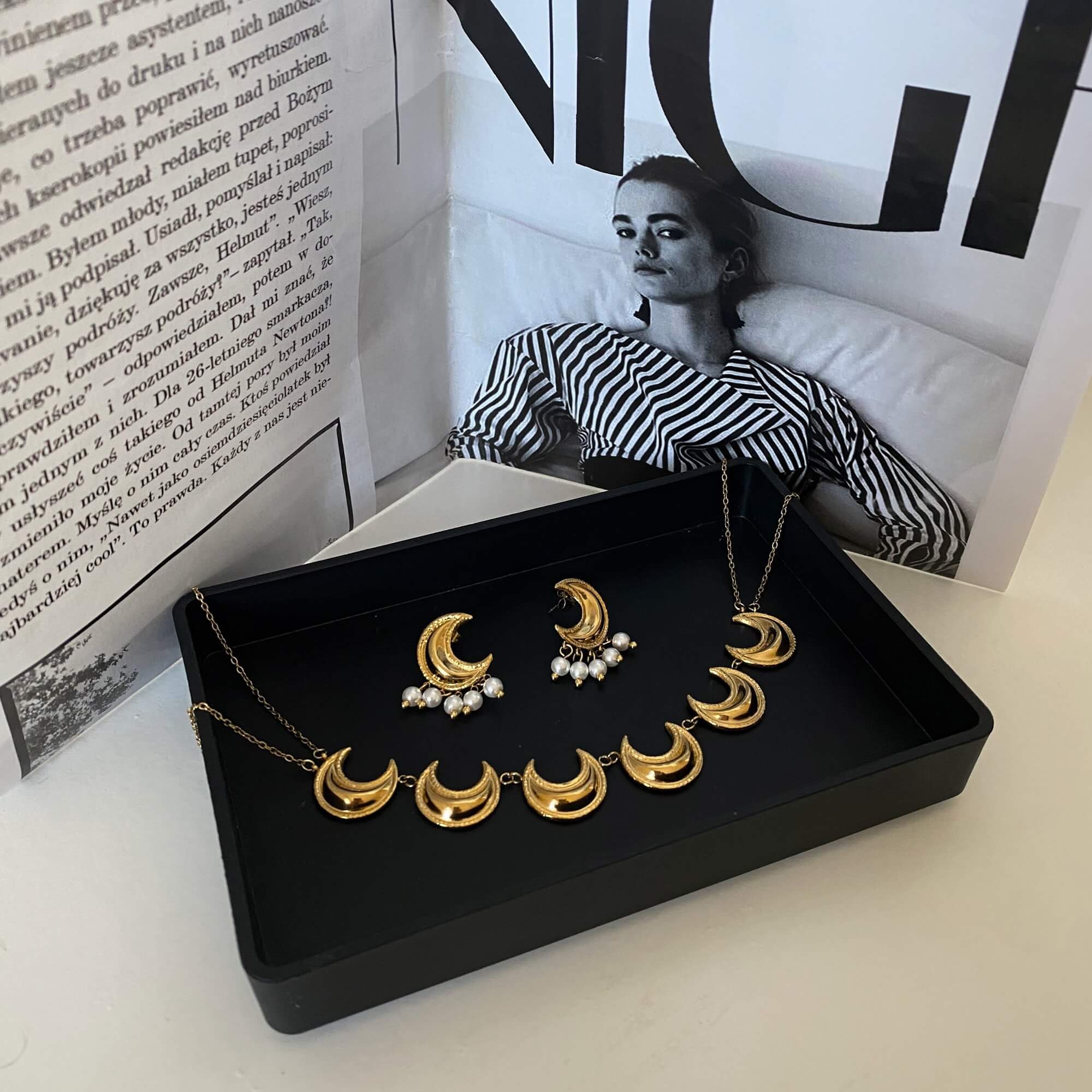 The KrescentN 18K gold-plated moon charm choker necklace by Kampy Designs, styled in a set with other celestial-inspired necklaces for a layered effect.