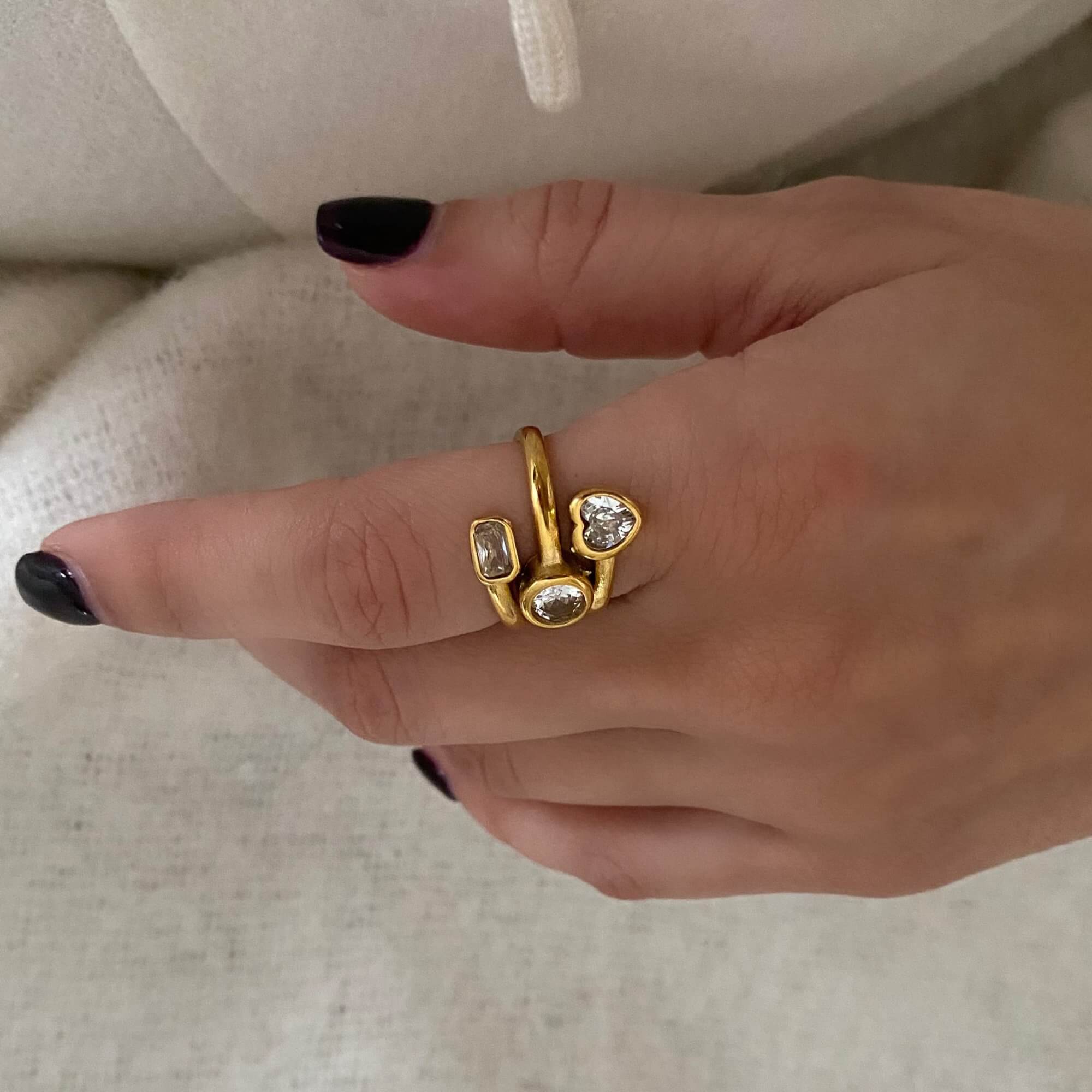 The KastleR 18K gold-plated multi-stone spiral ring by Kampy Designs, elegantly worn on a finger, showcasing its eye-catching brilliance and modern style.