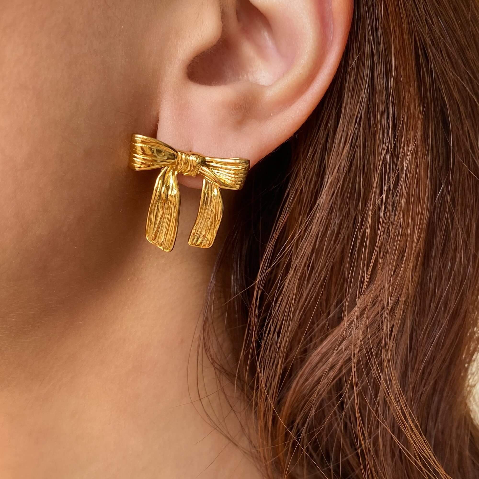 The KawlaE 18K gold-plated ribbon stud earrings by Kampy Designs, styled elegantly to showcase their timeless and feminine charm.