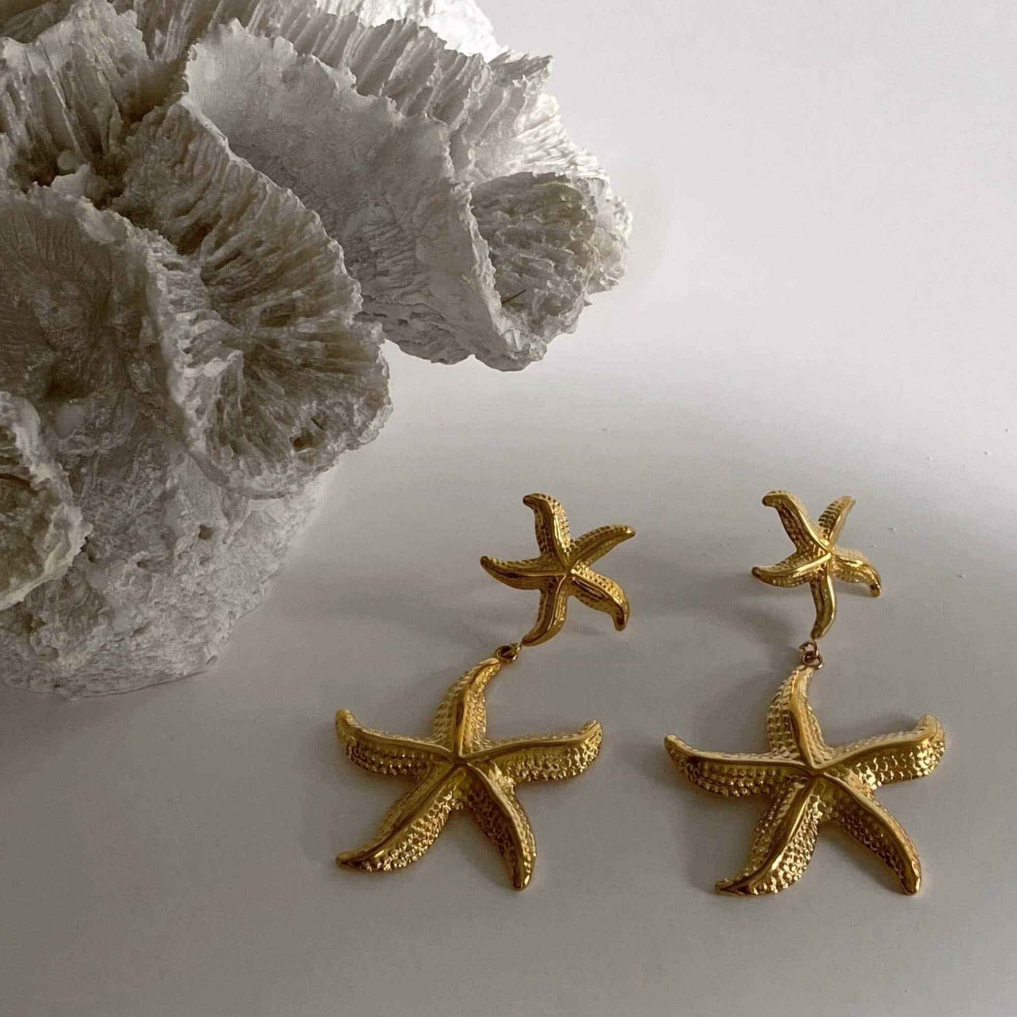 Front view of the KetaroE 18K gold-plated starfish dangle earrings by Kampy Designs, showcasing their intricate starfish shape and polished gold finish.