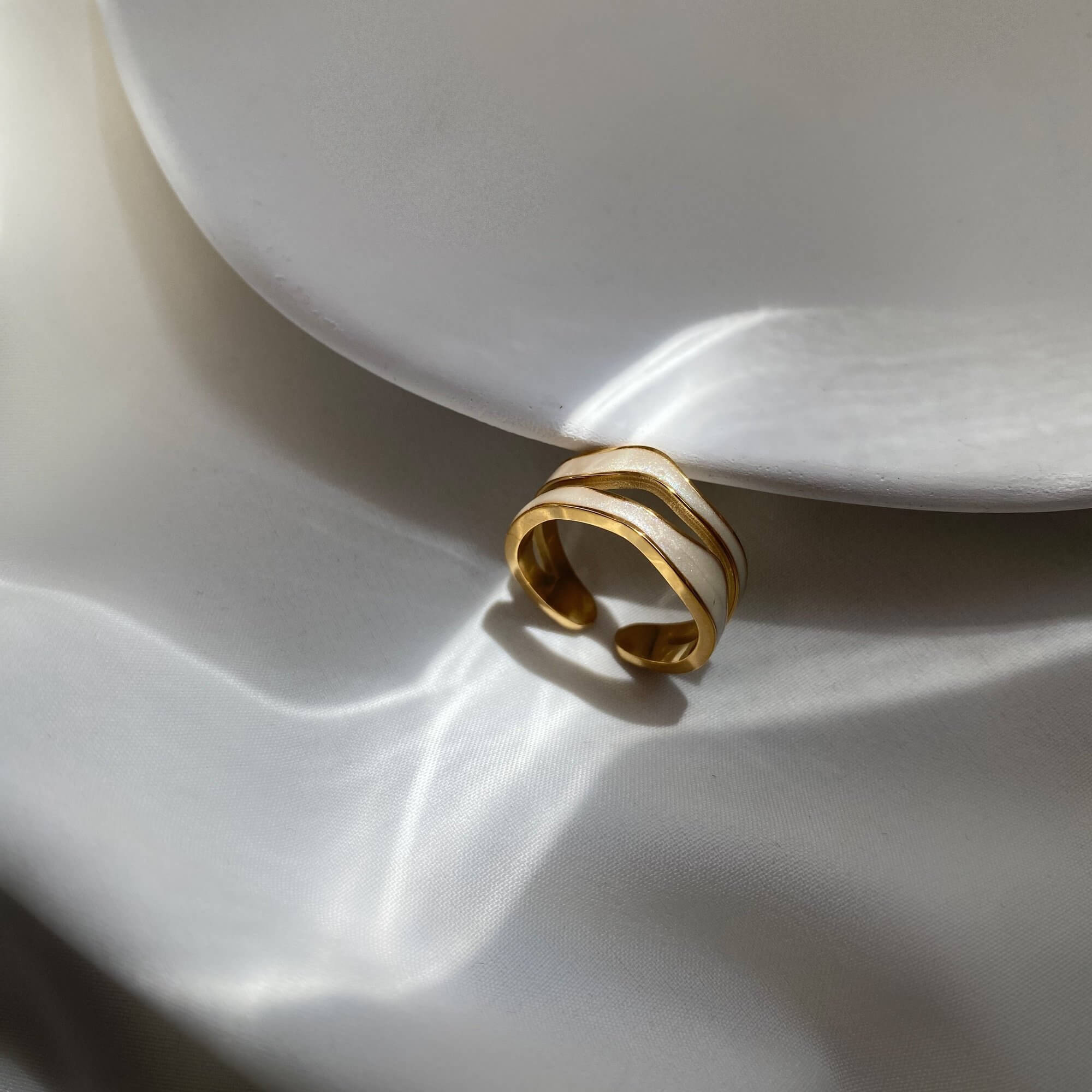 Angled view of the KalaR 18K gold-plated white enamel wave ring by Kampy Designs, highlighting its fluid wave-inspired design and smooth enamel finish.