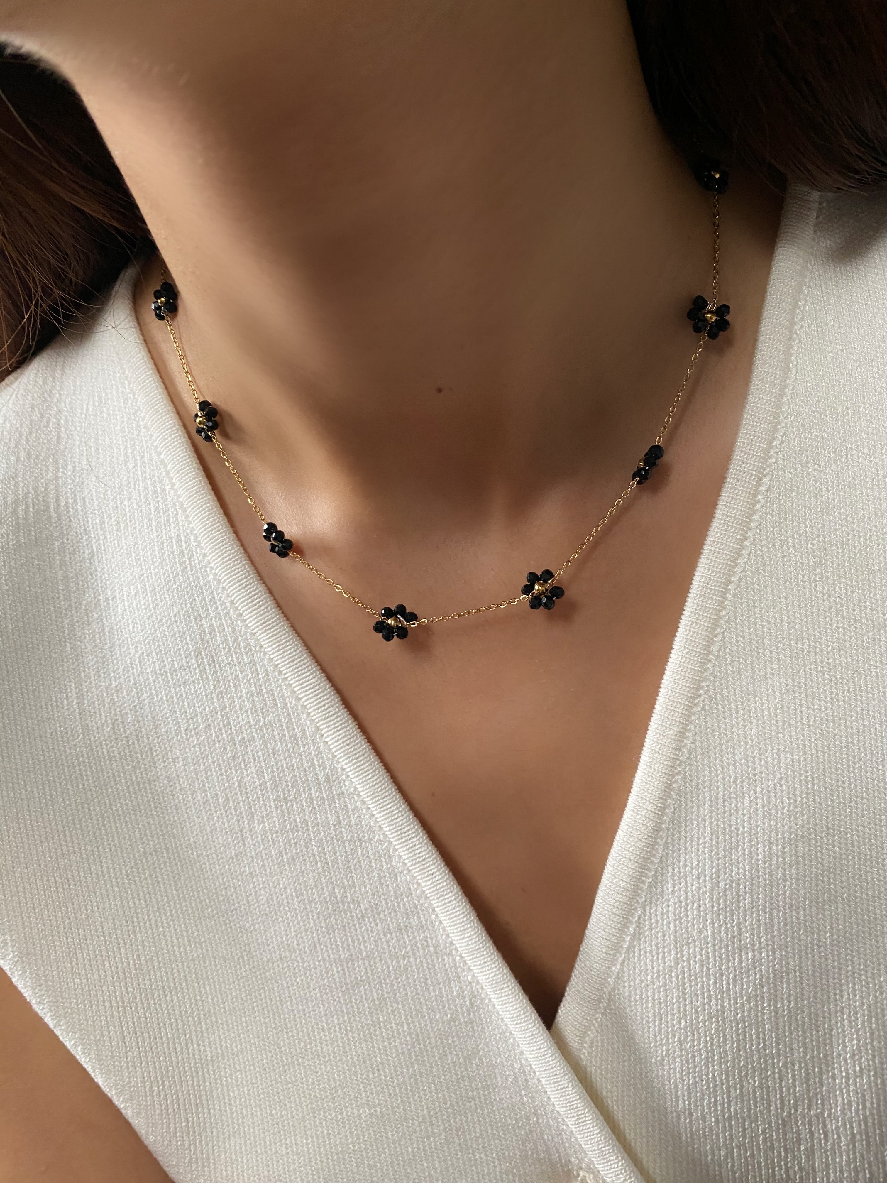 Close up of model wearing the Daisy Flower Choker in black, showcasing its elegant fit around the neck
