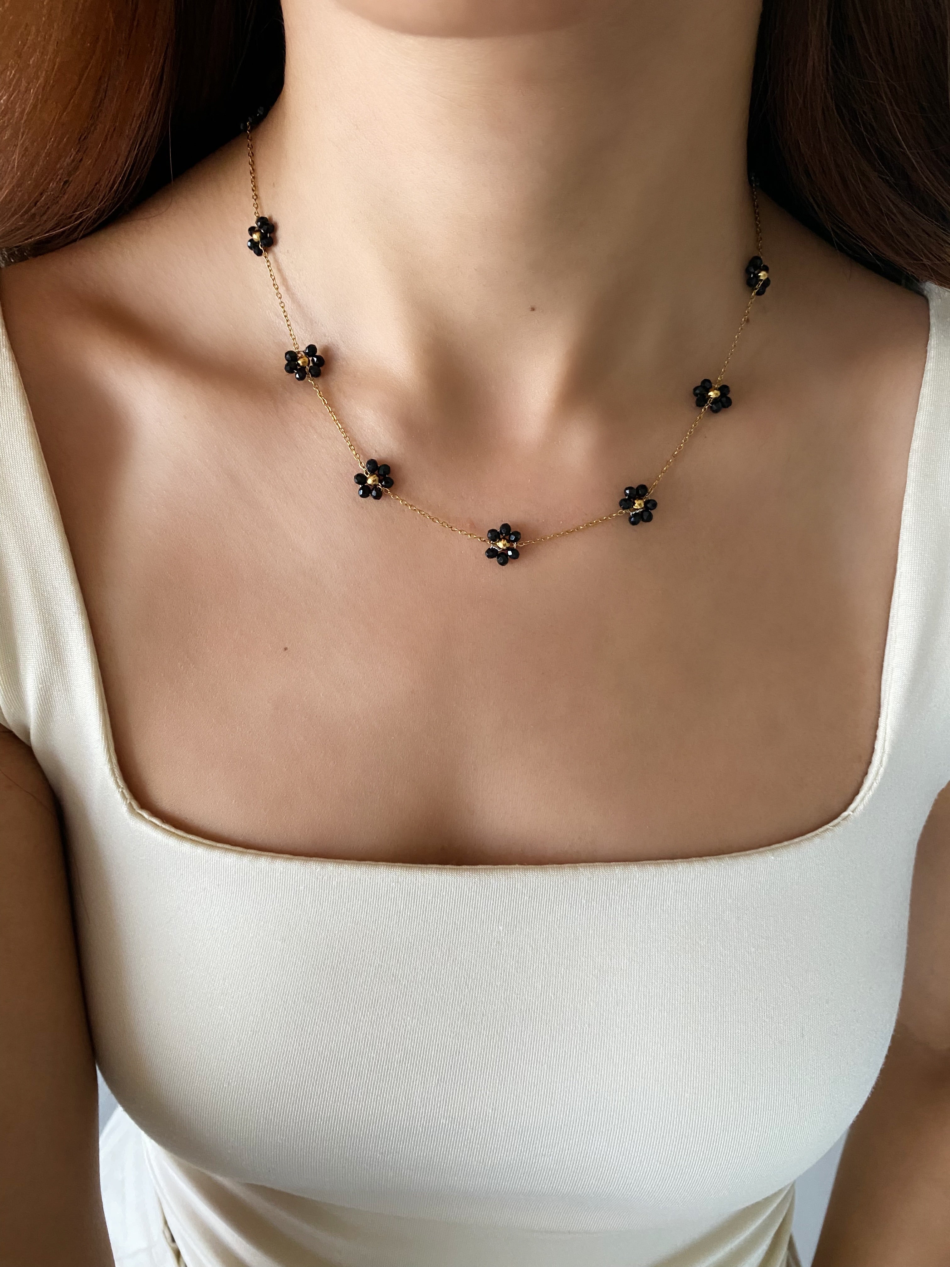 Close up of model wearing the Daisy Flower Choker in black, showcasing its elegant fit around the neck
