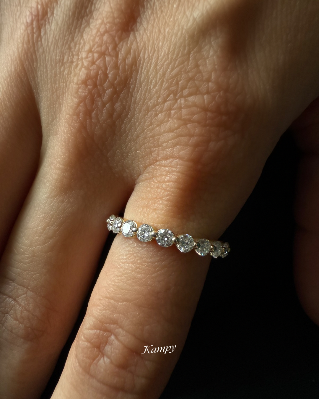 Moissanite eternity ring on a finger with a blurred background