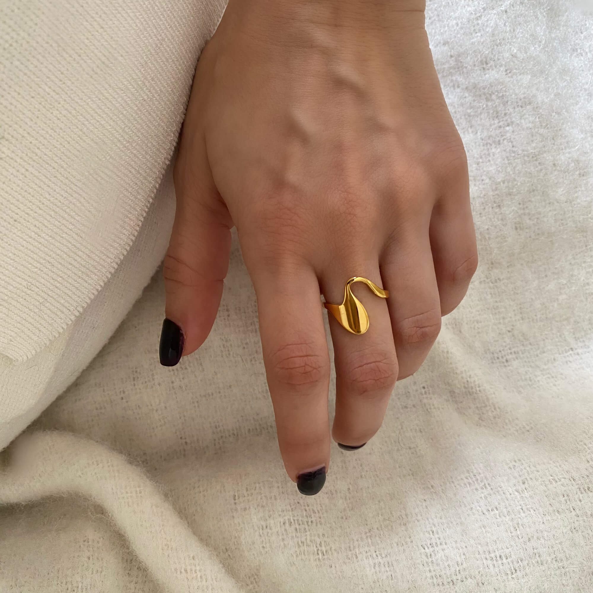 Close-up of the Abstract Liquid Metal Ring by Kampy Designs, worn on model’s hand to showcase its fluid, mirror-like surface and sculptural design.