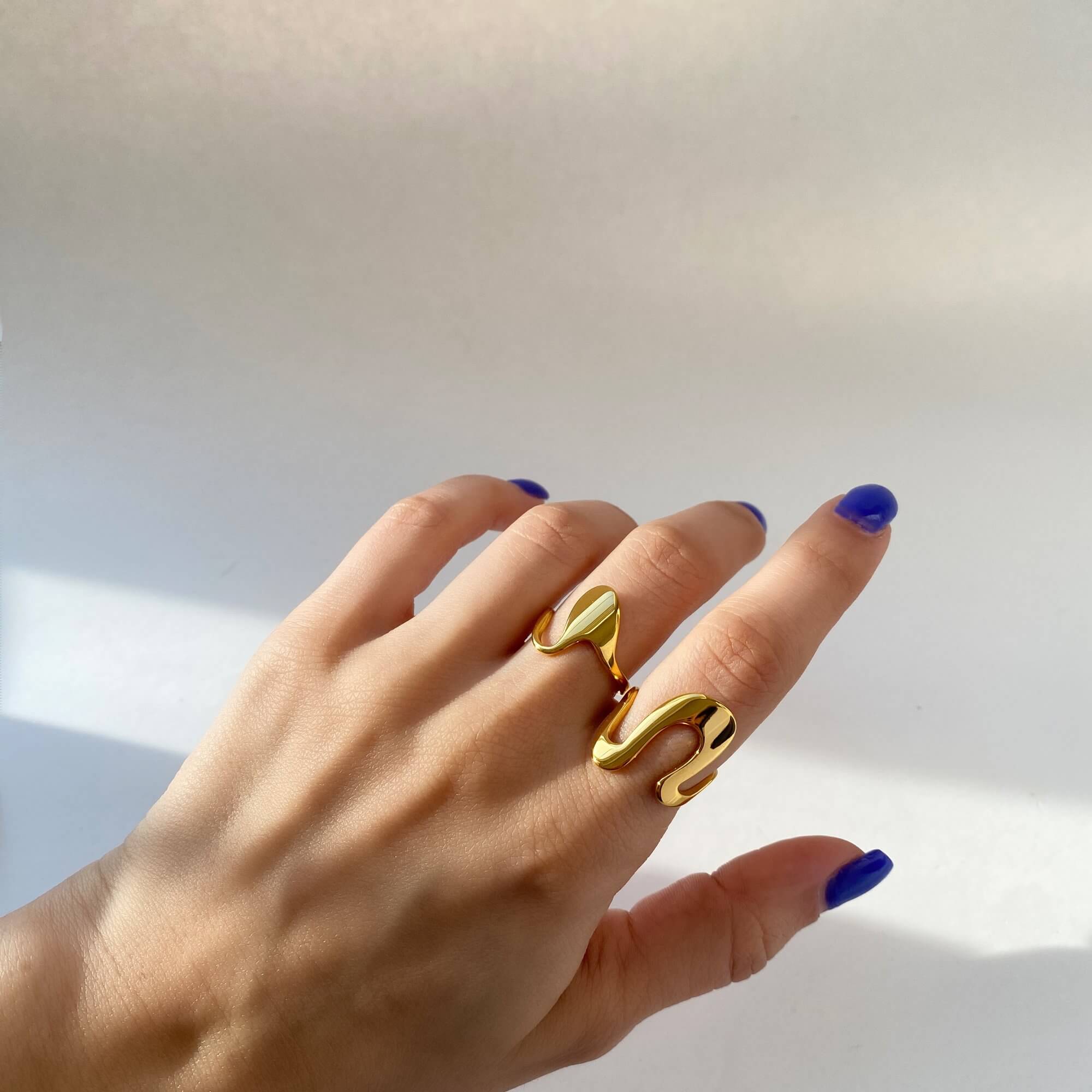 Angled shot of the Abstract Liquid Metal Ring by Kampy Designs, capturing its organic curves and fluid metal sheen from a dynamic angle.