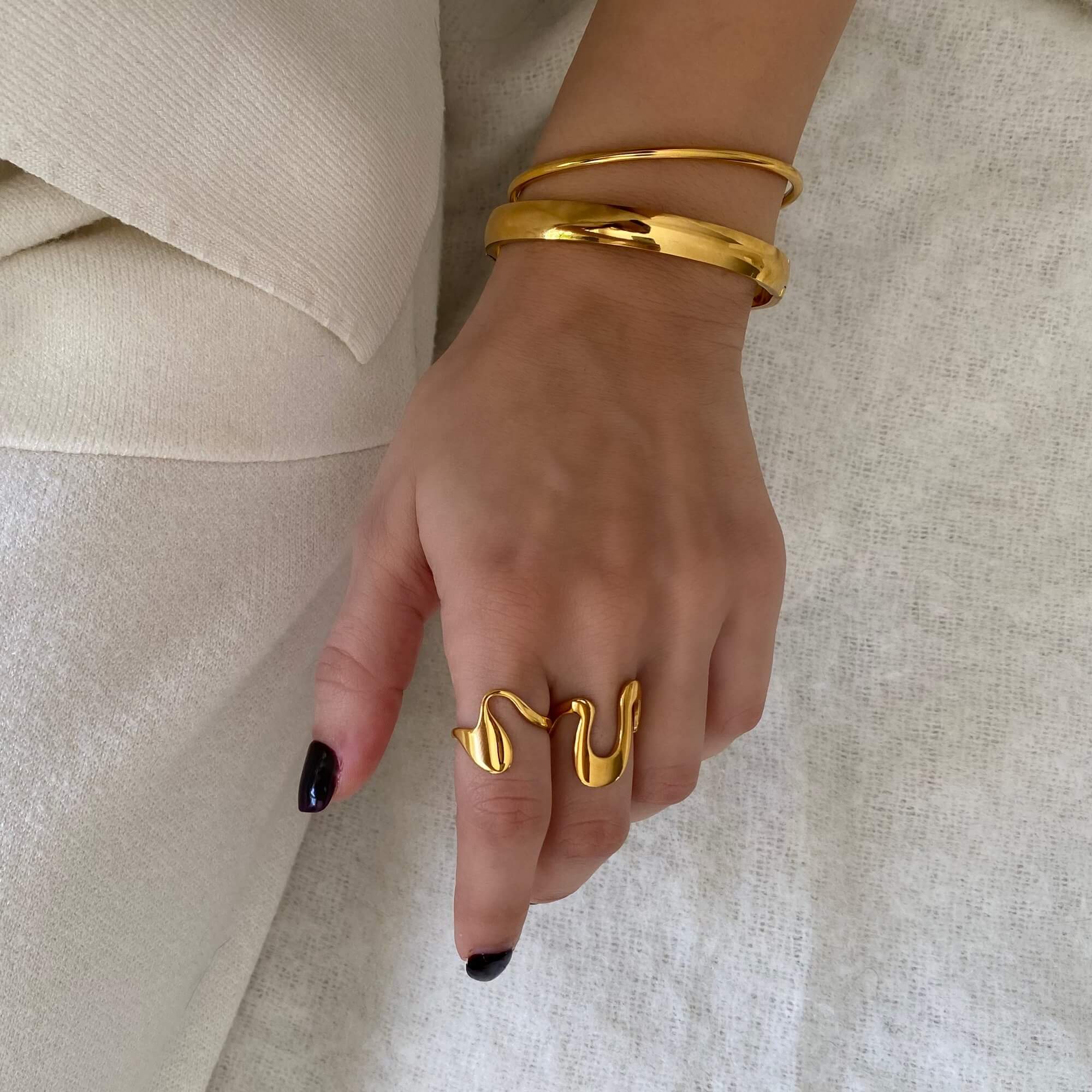 Styled photo of the Abstract Liquid Metal Ring by Kampy Designs, surrounded by complementary accessories for an artistic, editorial presentation.