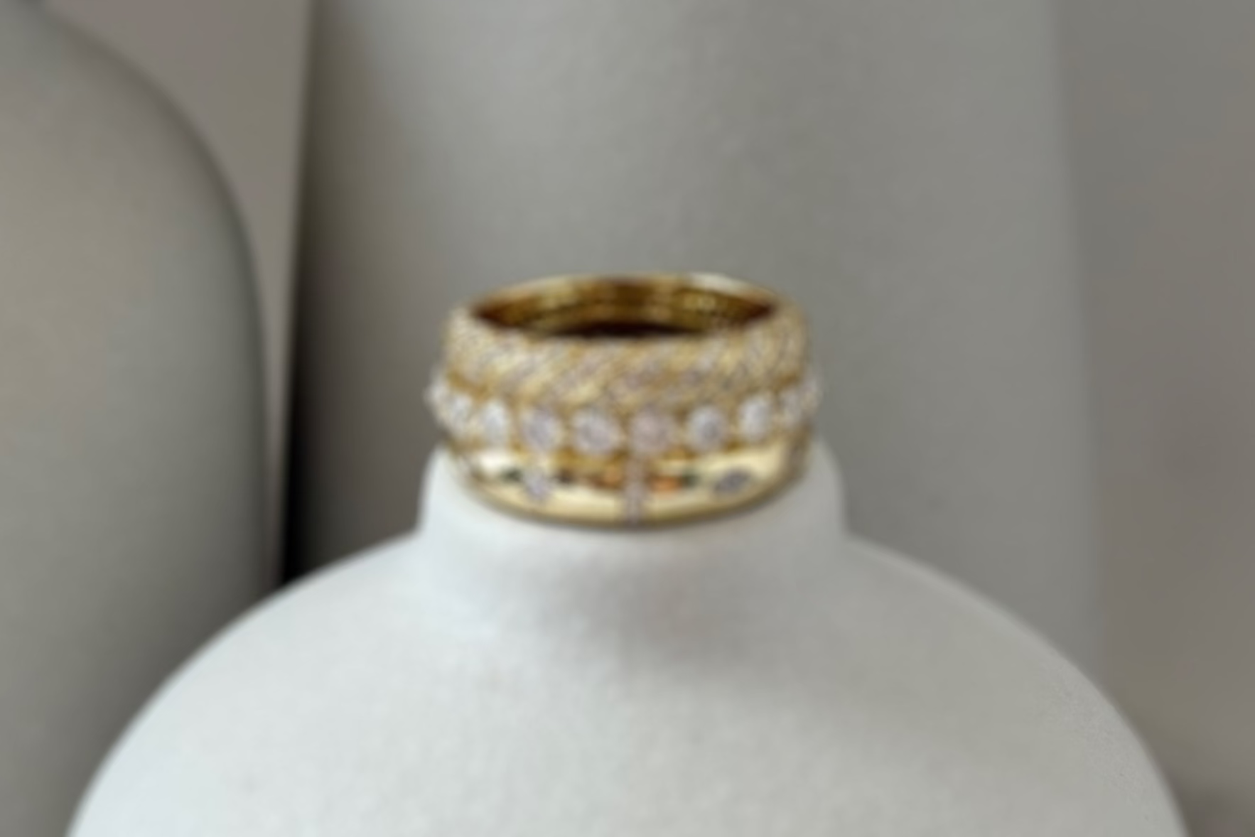 White ceramic bottle with gold moissanite rings stacked on top