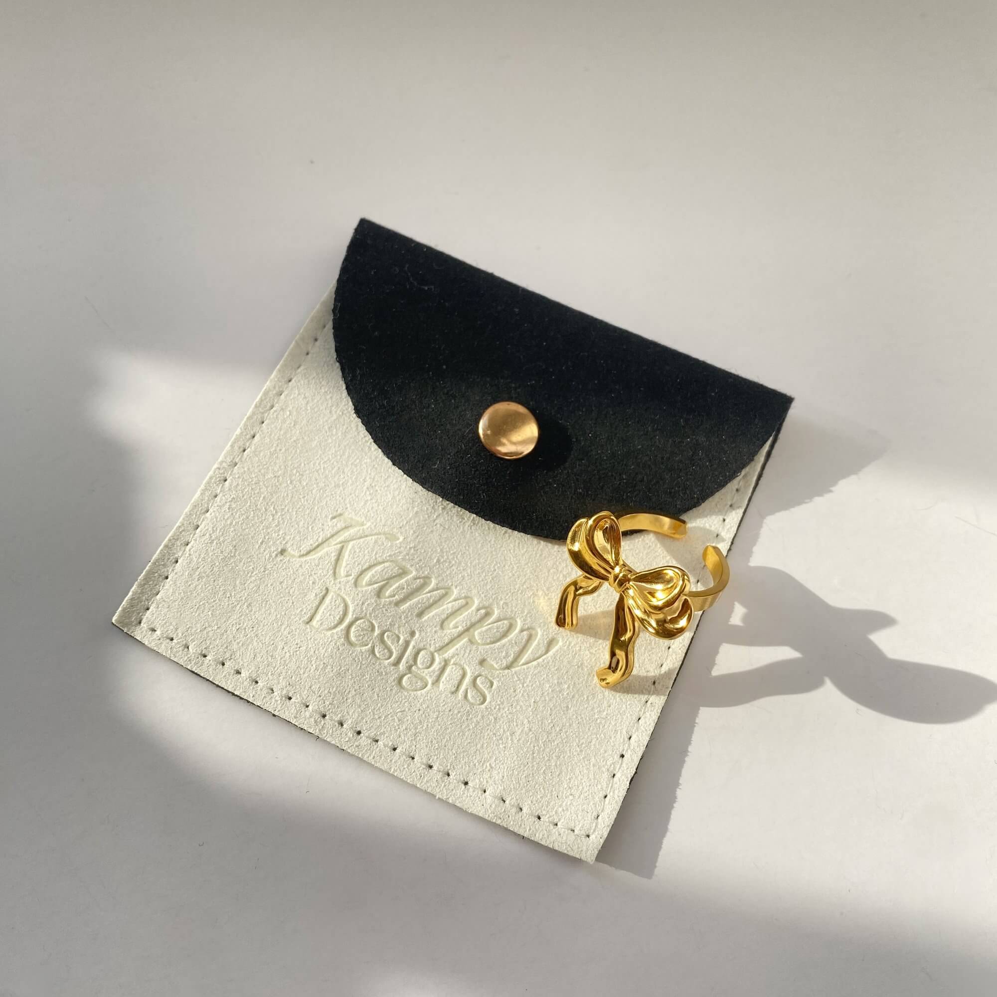 Side-angle flat lay of the Kinikir bow statement ring by Kampy Designs, emphasizing the arch and height of the elegant bow detail.