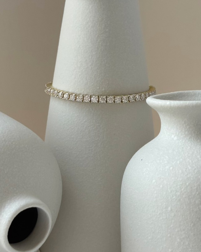 Gold bracelet with diamonds on a white surface