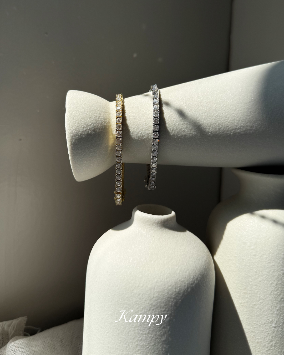 Two bracelets on a ceramic vase, branded 'Kampy'.