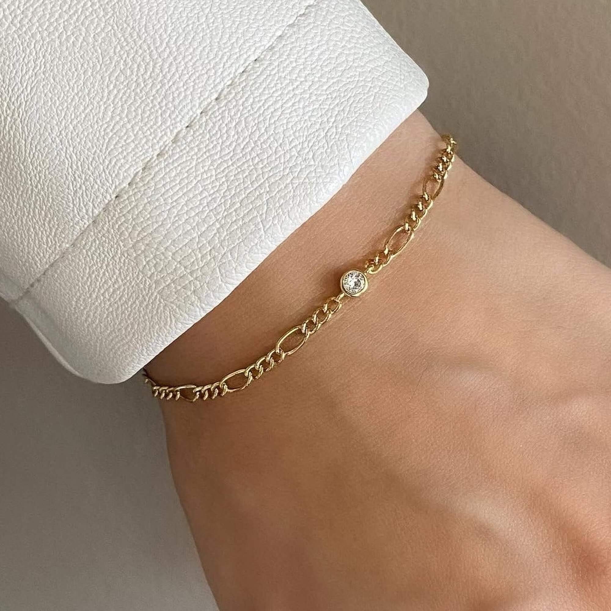 The KianaB CZ gemstone Figaro chain bracelet by Kampy Designs, showcasing a sparkling clear cubic zirconia stone set in a sleek Figaro chain.