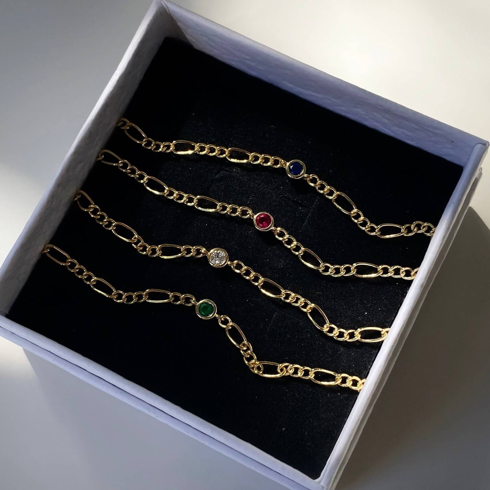 Front view of the KianaB CZ gemstone Figaro chain bracelet by Kampy Designs, showcasing its intricate Figaro link chain and dazzling gemstone centerpiece.