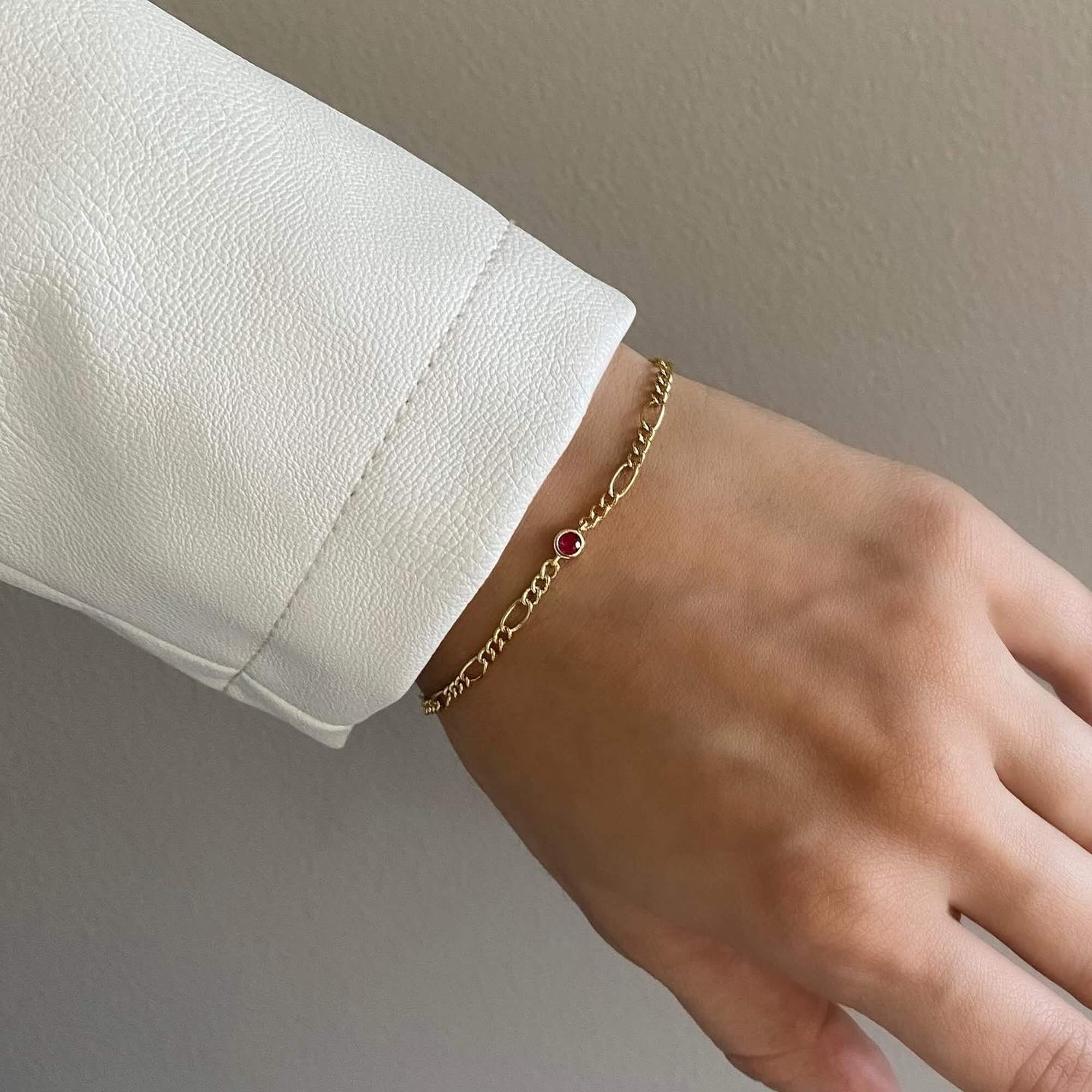 The KianaB CZ gemstone Figaro chain bracelet by Kampy Designs, featuring a vibrant ruby-colored cubic zirconia stone set in a classic Figaro chain.