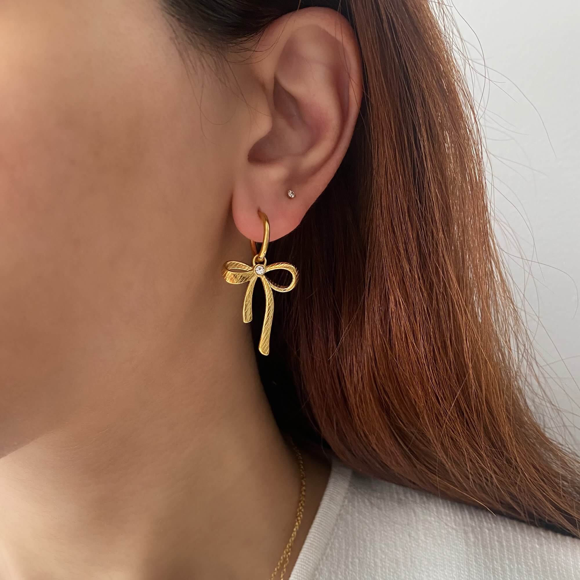 KrissaE dainty bow dangle earrings by Kampy Designs, worn by model for a delicate and graceful jewelry look.