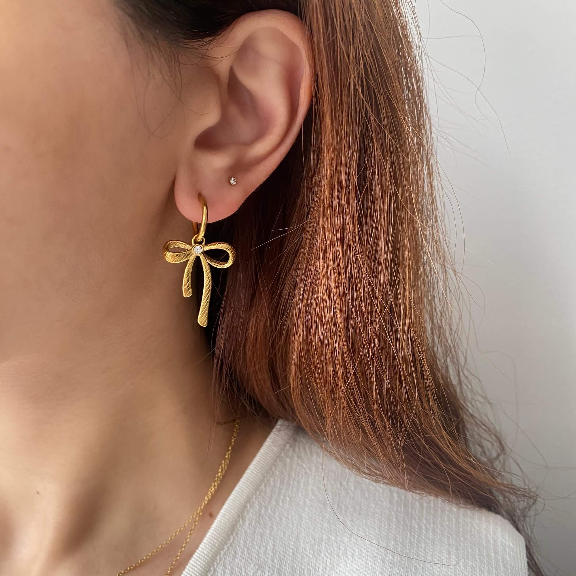 Styled shot of KrissaE dainty bow dangle earrings by Kampy Designs, styled on model in an editorial setup for a dreamy aesthetic.