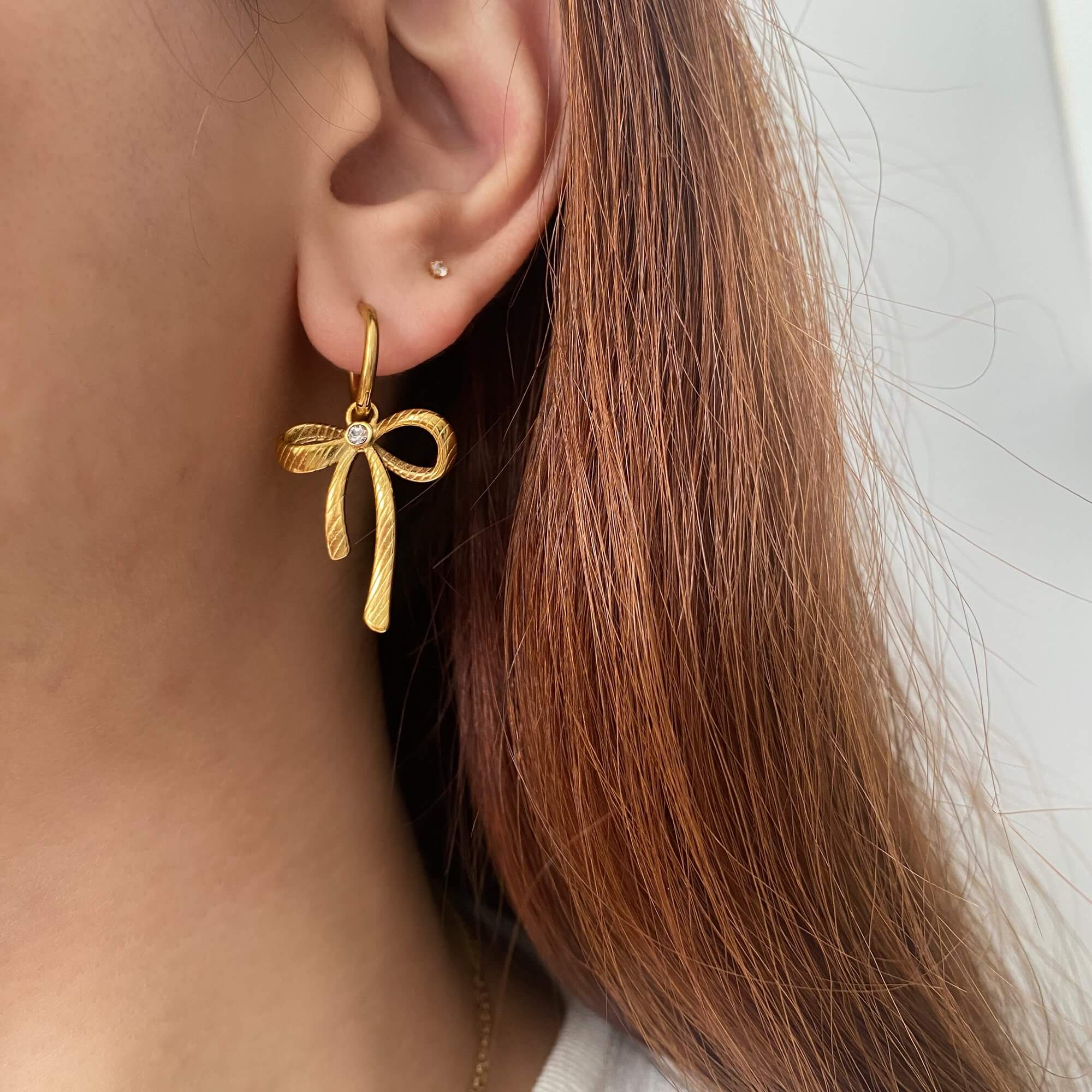 Close-up of KrissaE dainty bow dangle earrings by Kampy Designs, highlighting the delicate bow design with elegant drop length.