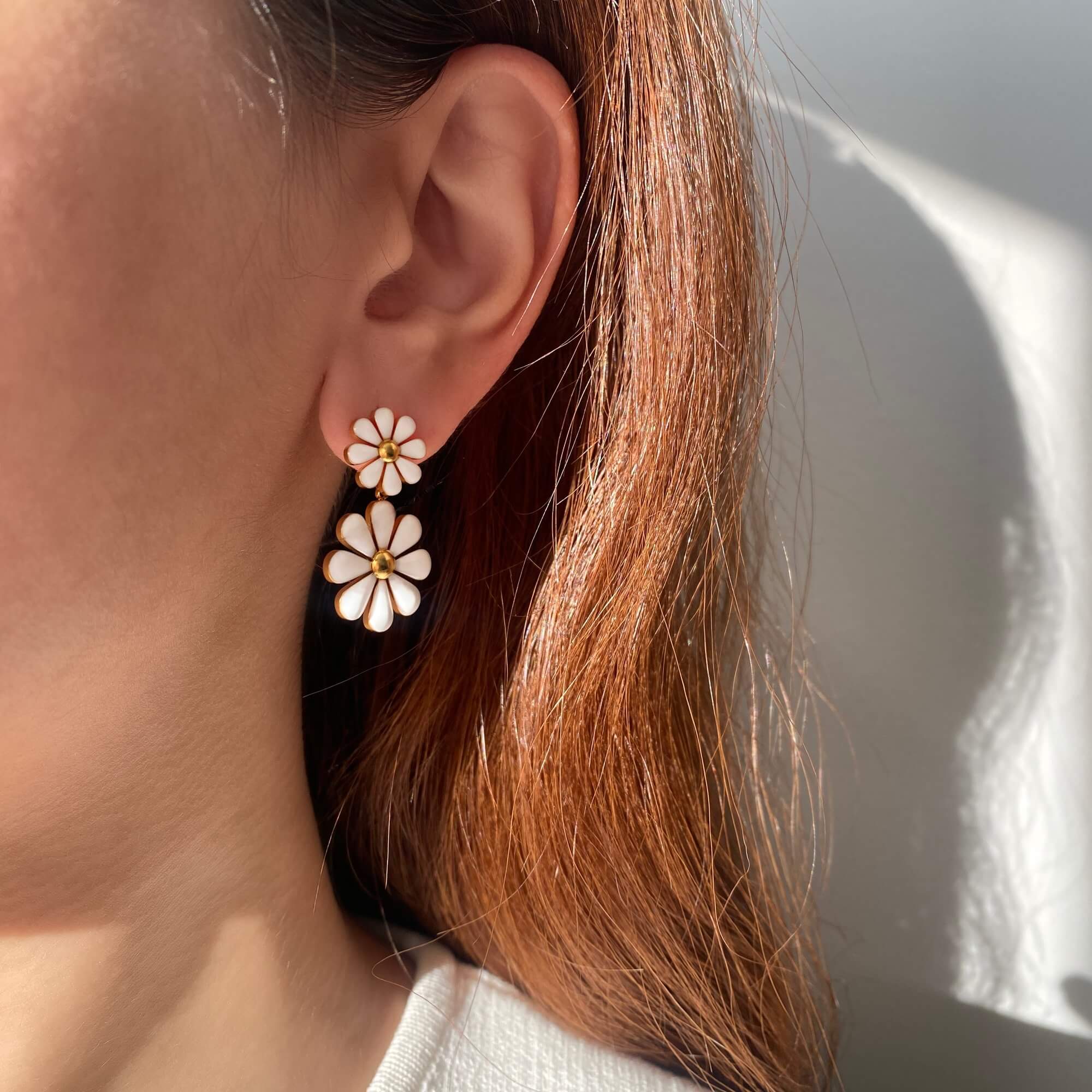 KendyR daisy drop earrings by Kampy Designs, worn on model's ear at an angle to highlight the playful petal design and gold accents.