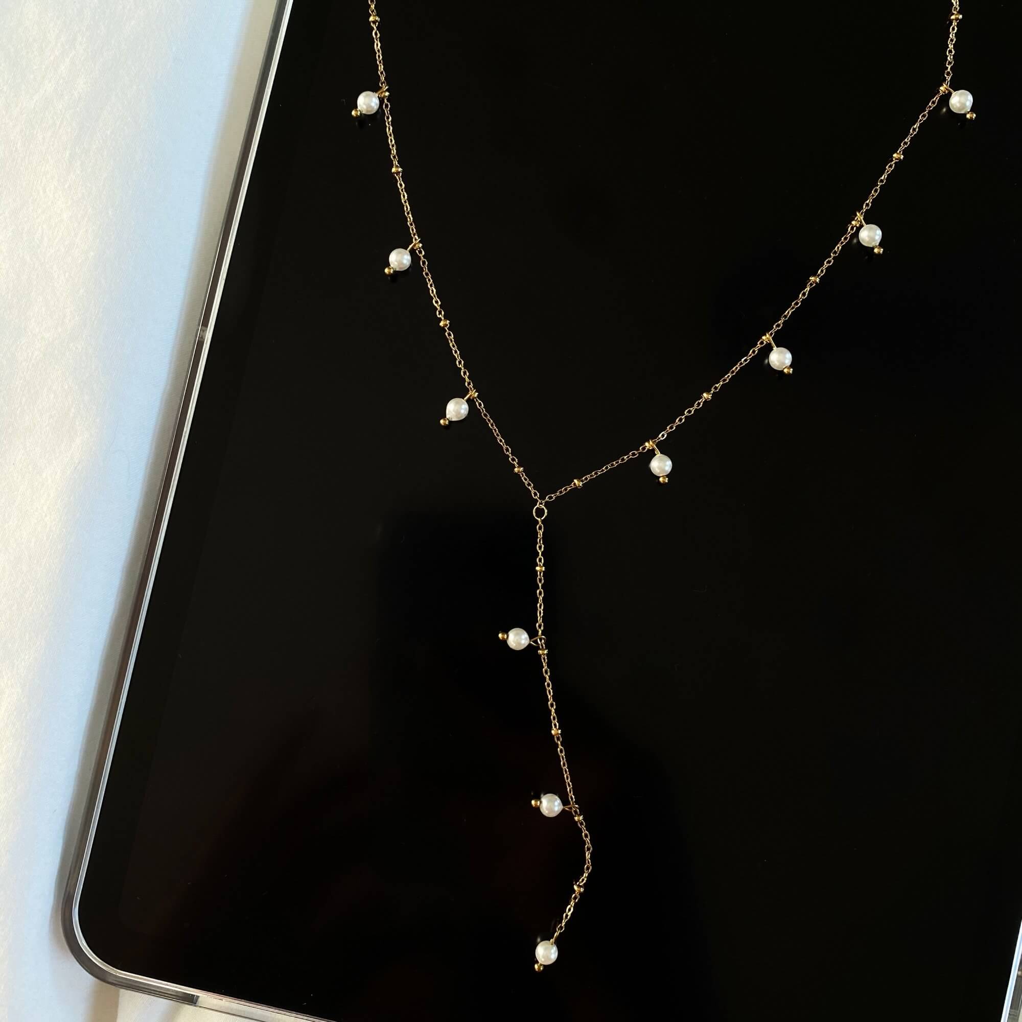 Top view of the KleopatraN freshwater pearl charm lariat necklace by Kampy Designs, showcasing its elegant Y-drop design and exquisite pearl accent.