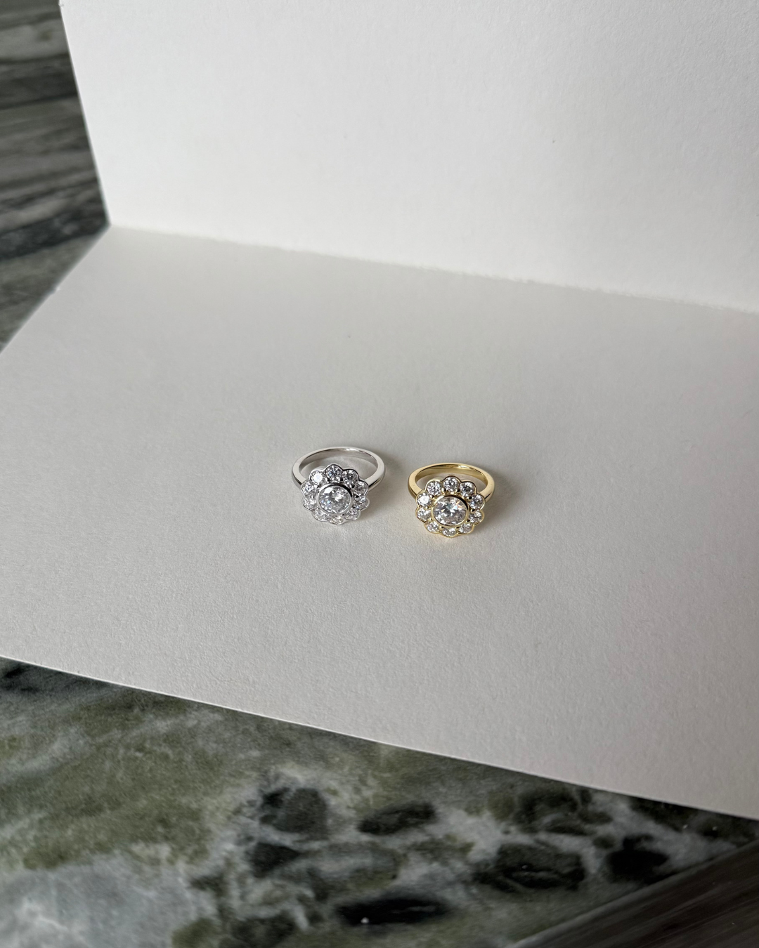 The Marigold Ring from Kampy Designs shown in both gold and silver finishes side-by-side, each featuring a floral moissanite halo design.