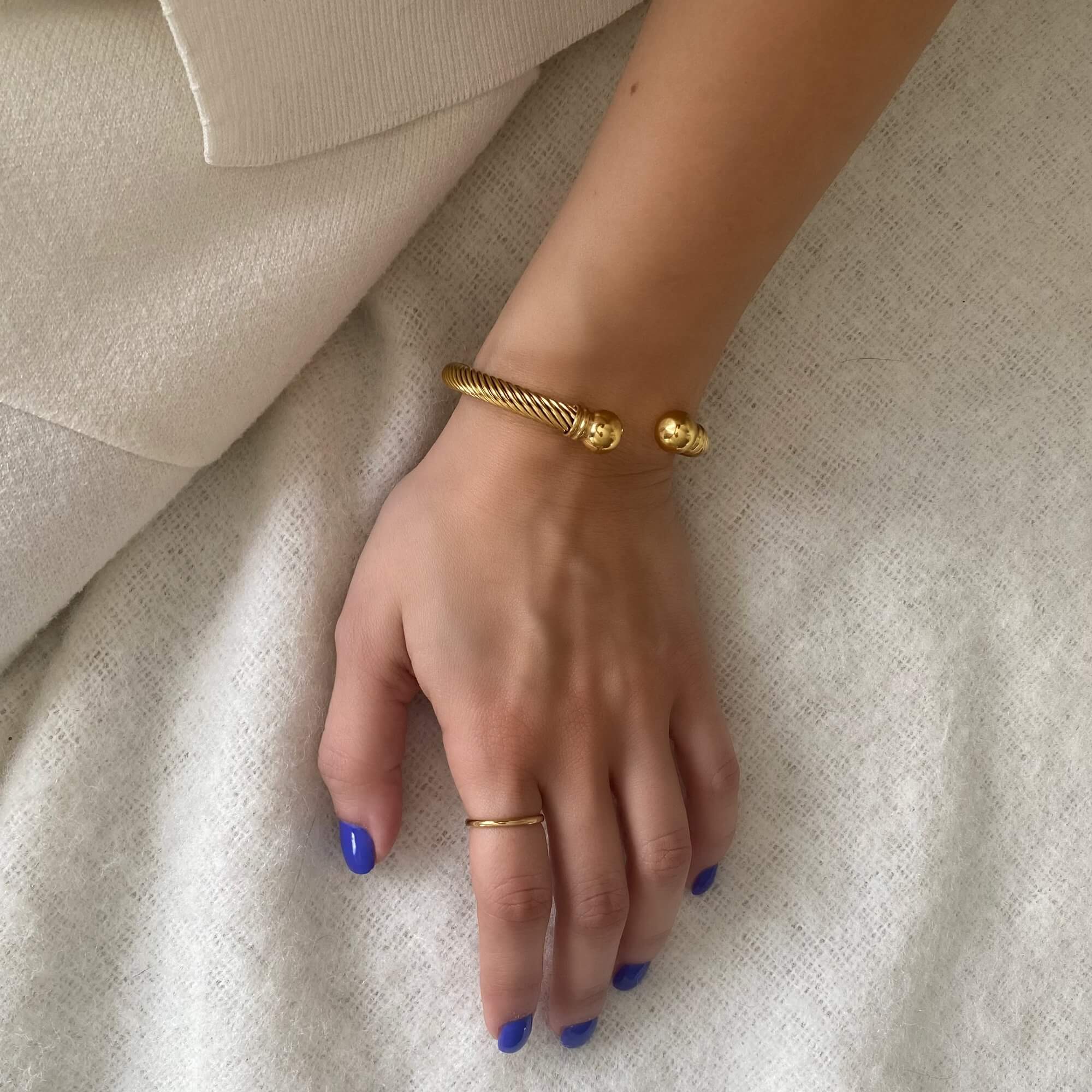 Angled view of the KammyB gold twist cuff bracelet by Kampy Designs, showcasing its elegant spiral design and lustrous gold finish.