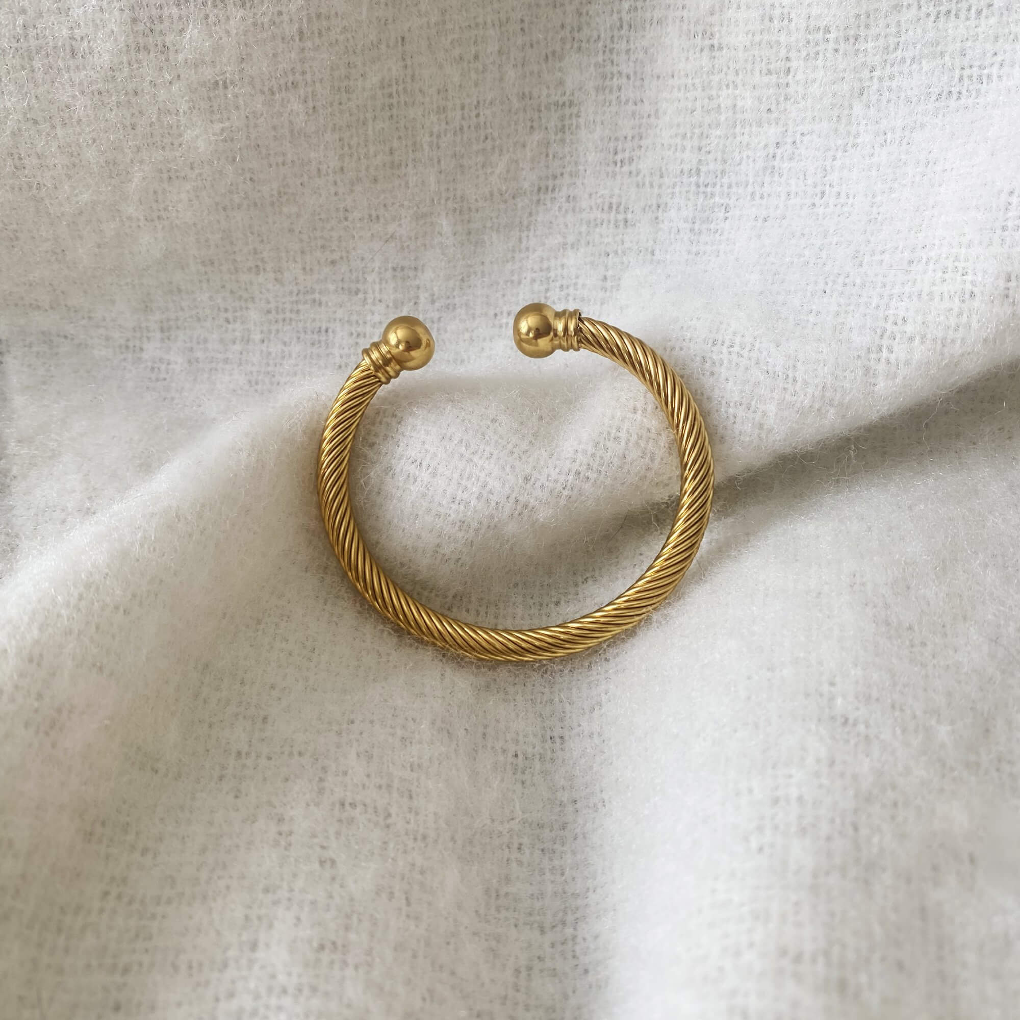Close-up of the KammyB gold twist cuff bracelet by Kampy Designs, emphasizing the detailed twisting pattern and high-shine polish.