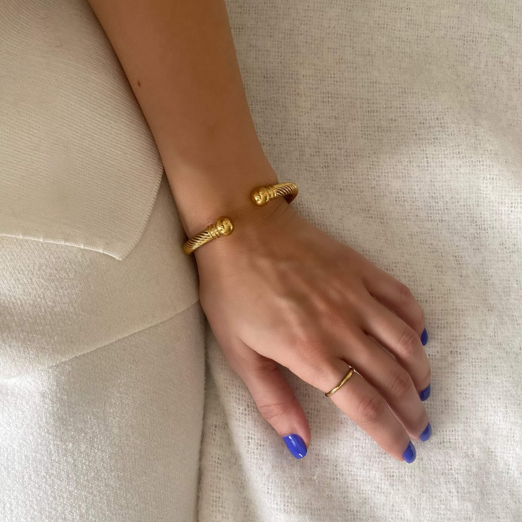 Side profile of the KammyB gold twist cuff bracelet by Kampy Designs, showing its open-ended cuff shape and fluid twist structure.