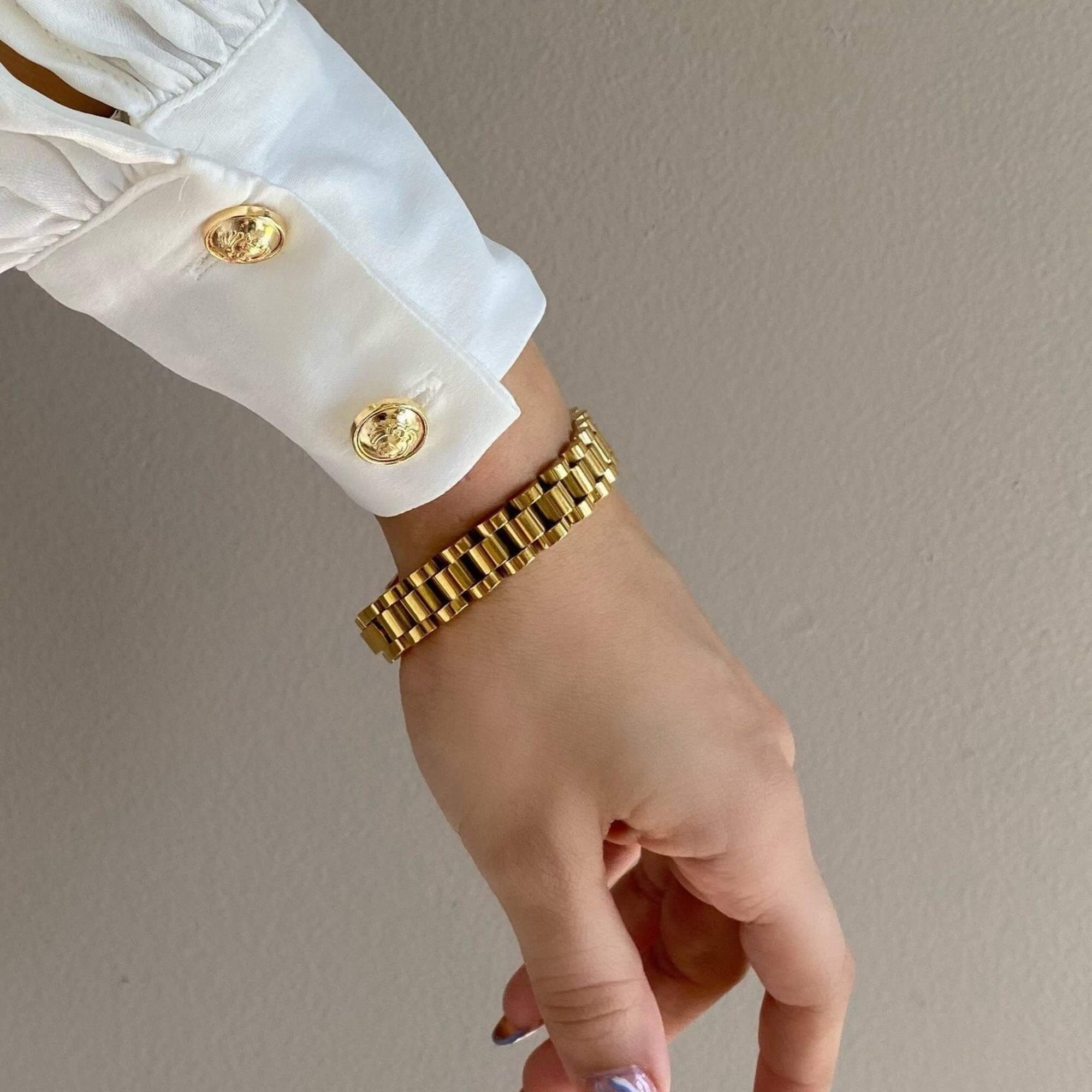 The KennedyB gold watch band bracelet by Kampy Designs, elegantly worn to highlight its polished gold finish and timeless watch-style bracelet design.
