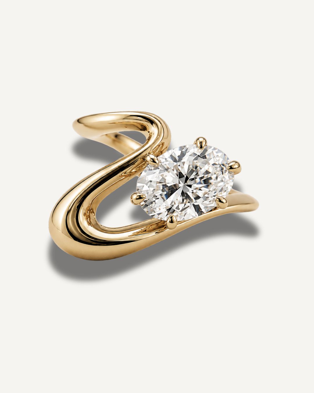 Gold wave band pinky ring with oval moissanite center stone in a clean front view on a neutral background
