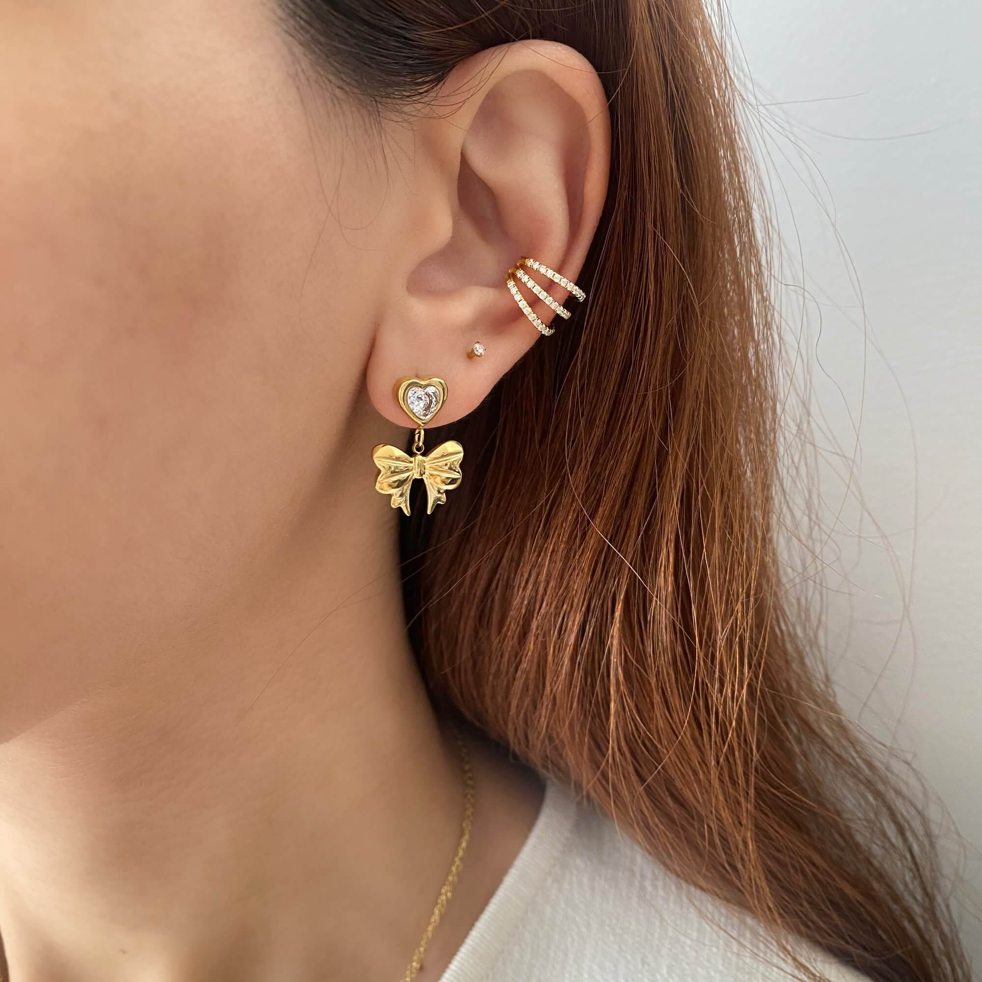 Styled look of KutieE heart bow dangle earrings by Kampy Designs, worn on model with soft lighting to create a romantic, editorial mood.