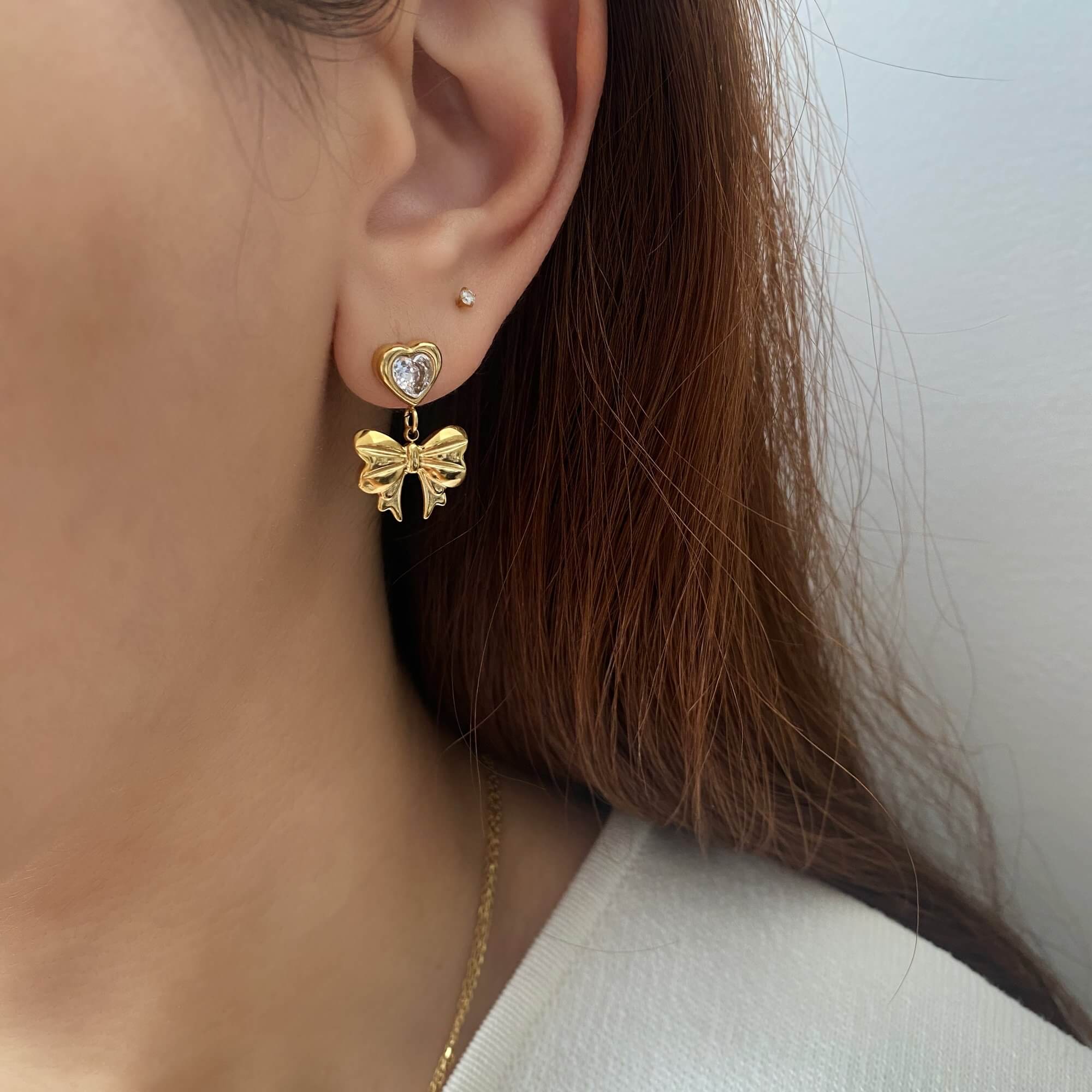 Side profile of KutieE heart bow dangle earrings by Kampy Designs, showing the layered bow and heart design in delicate detail.
