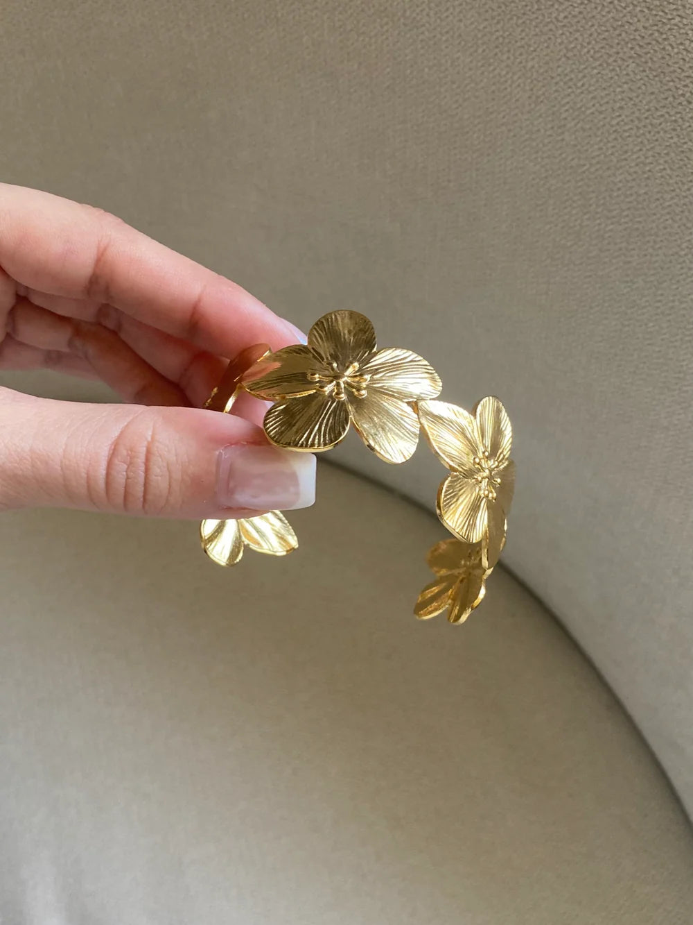 Angled view of the KloraB hibiscus flower cuff bracelet by Kampy Designs, showcasing its delicate floral engravings and gold-tone finish.