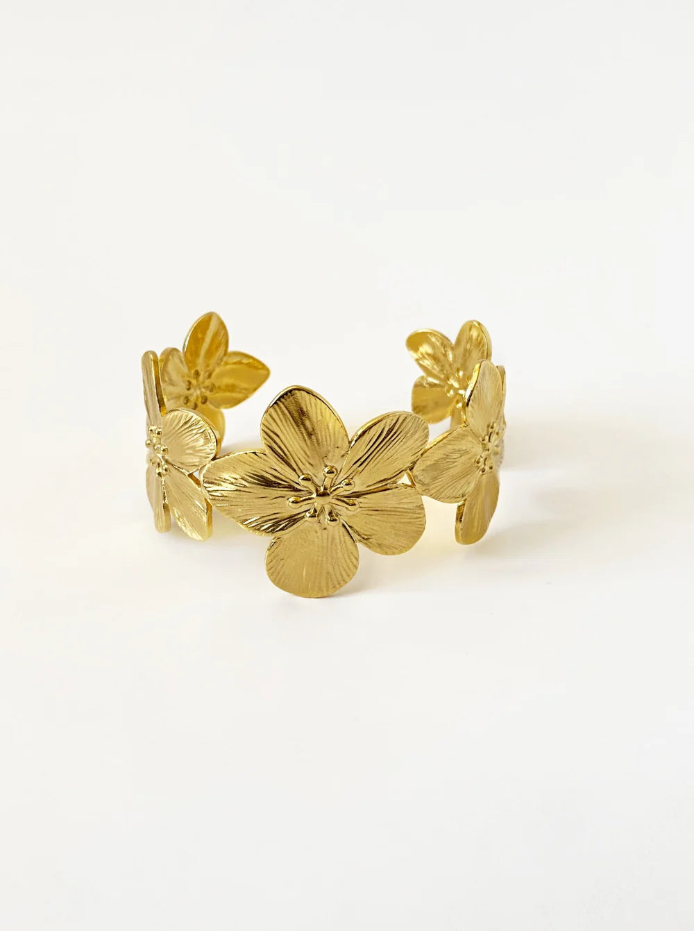 Side view of the KloraB hibiscus flower cuff bracelet by Kampy Designs, showcasing its smooth gold finish and floral embellishments.