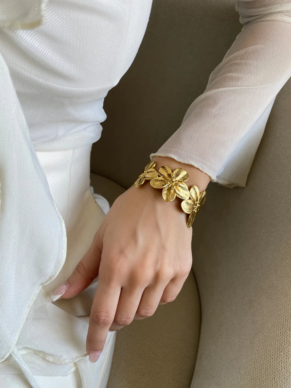 The KloraB hibiscus flower cuff bracelet by Kampy Designs, beautifully worn to highlight its delicate floral engravings and elegant cuff design.