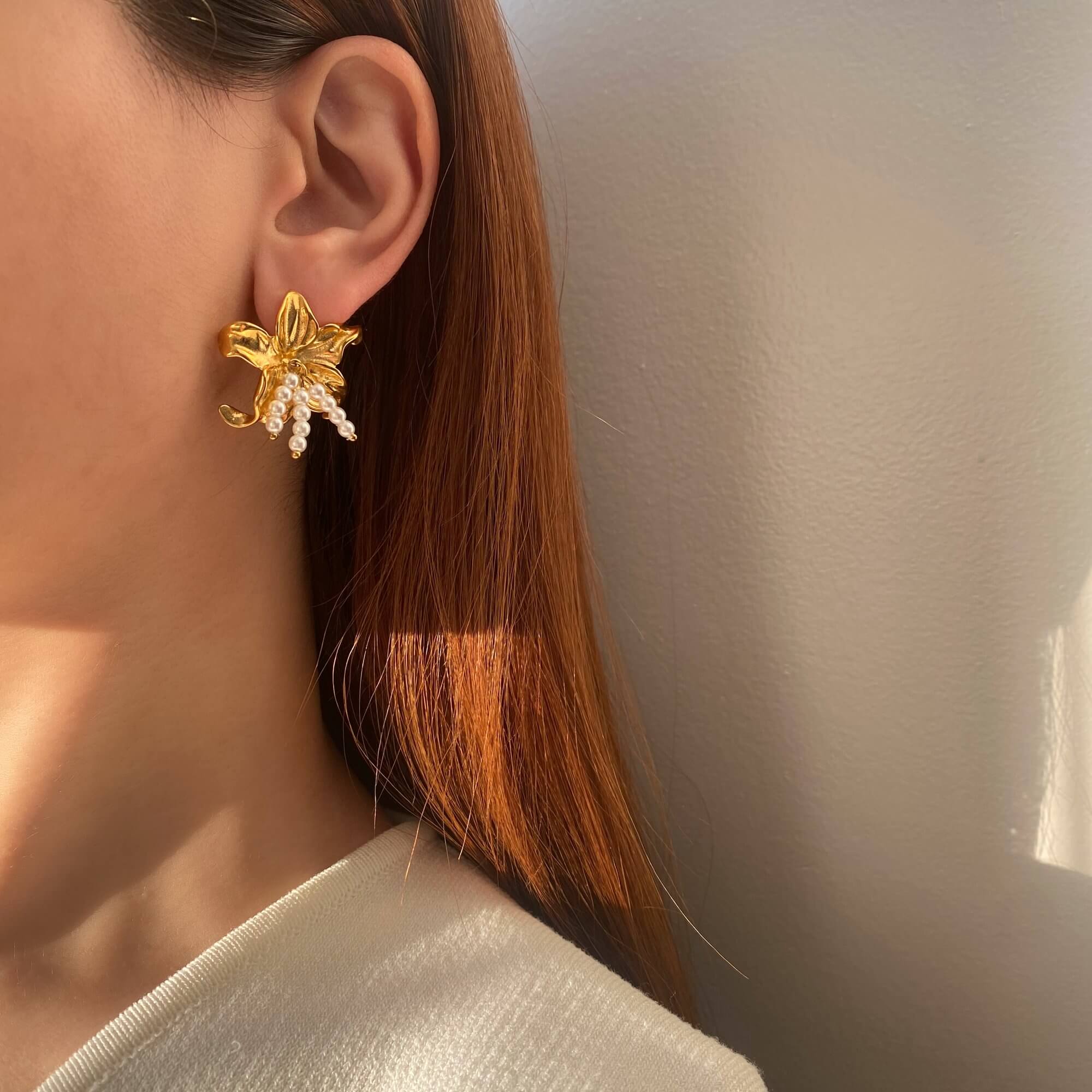 Kawaiie hibiscus flower stud earrings by Kampy Designs, worn by model from a distance to showcase subtle elegance.
