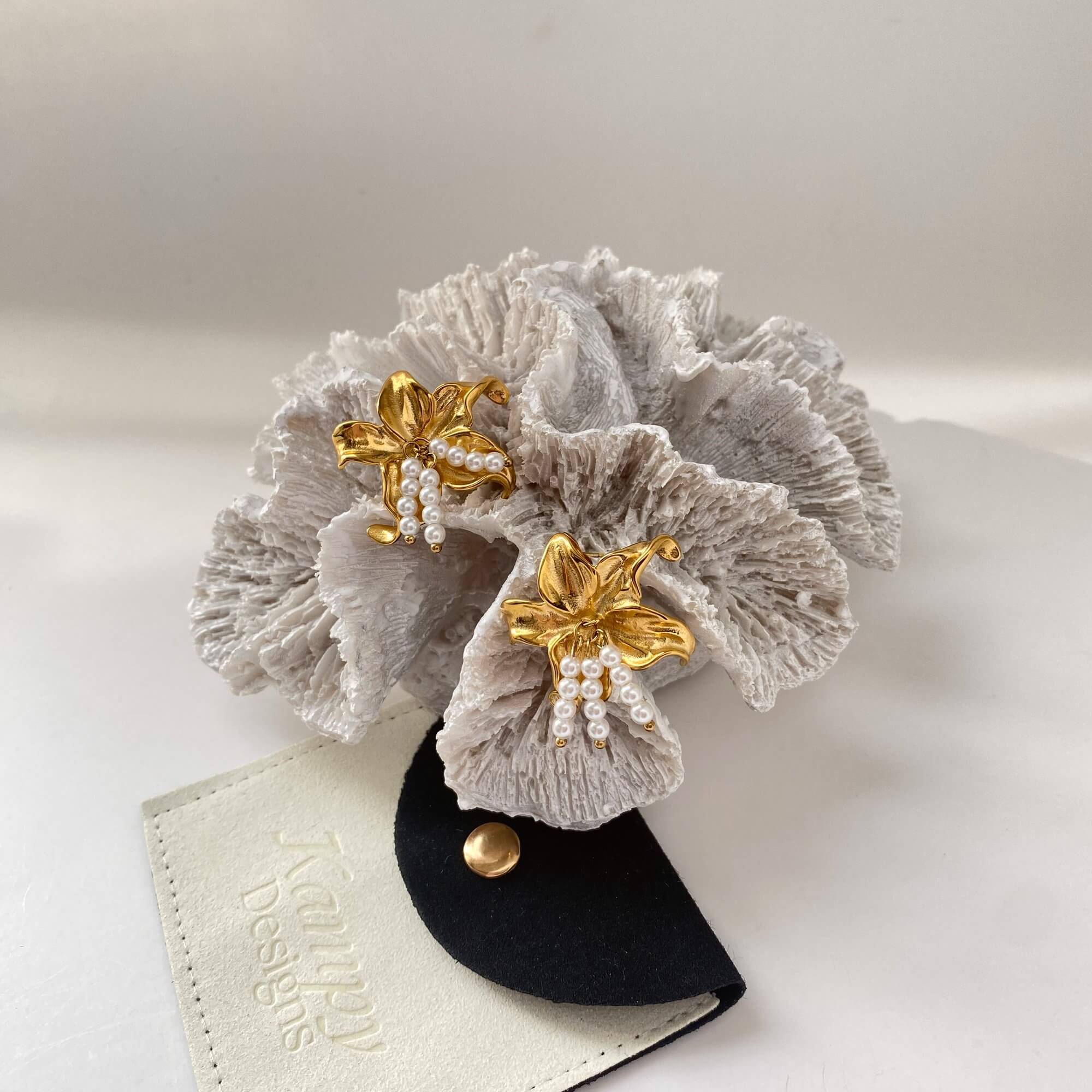 Styled editorial photo of the Kawaiie hibiscus flower stud earrings by Kampy Designs, paired with accessories for a botanical look.