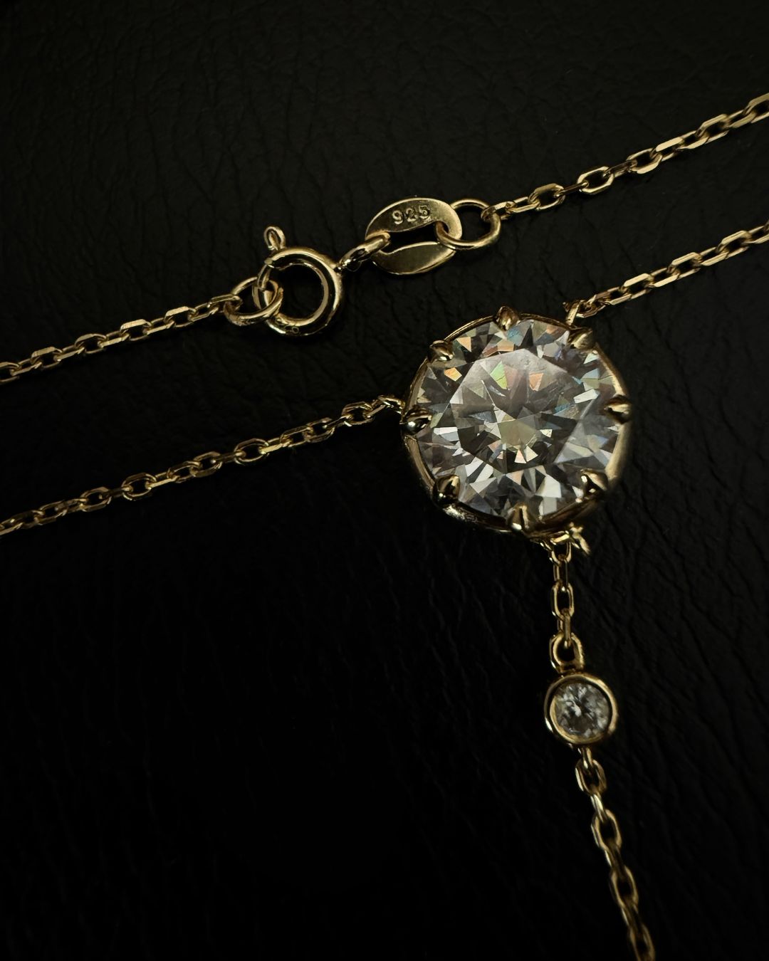 Close-up of the Lumina Drop Necklace showing the gold chain, clasp and 3 ct round moissanite center stone setting.