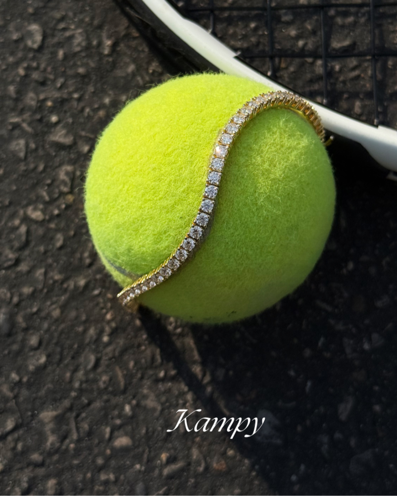 Tennis ball with a diamond-studded band on a racket against a textured surface
