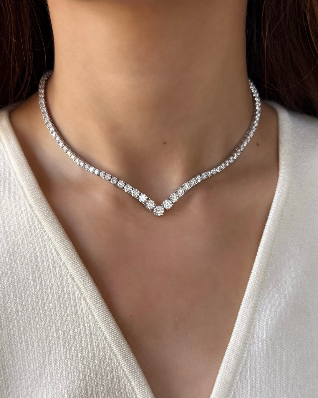 Diamond necklace on a model wearing a white top