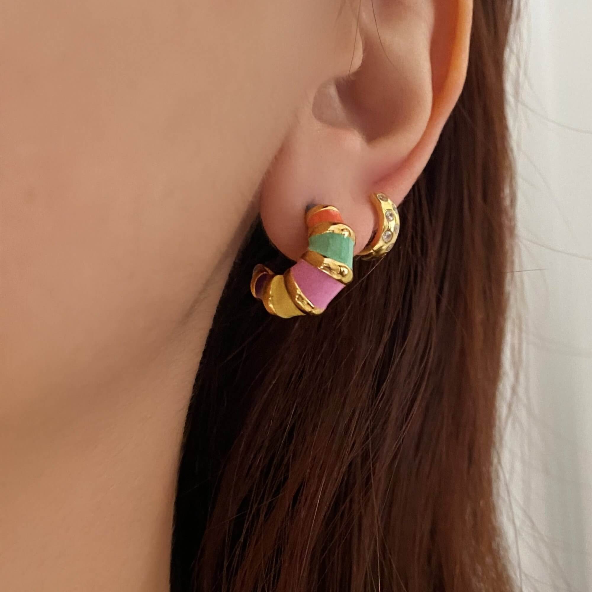 The KrosantE multi-color enamel hoop earrings by Kampy Designs, beautifully worn to highlight their trendy and playful enamel design.