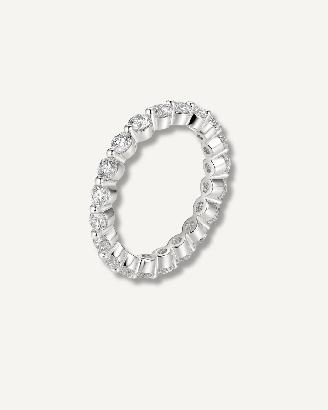Round moissanite eternity band in silver finish on neutral background, Kampy Designs