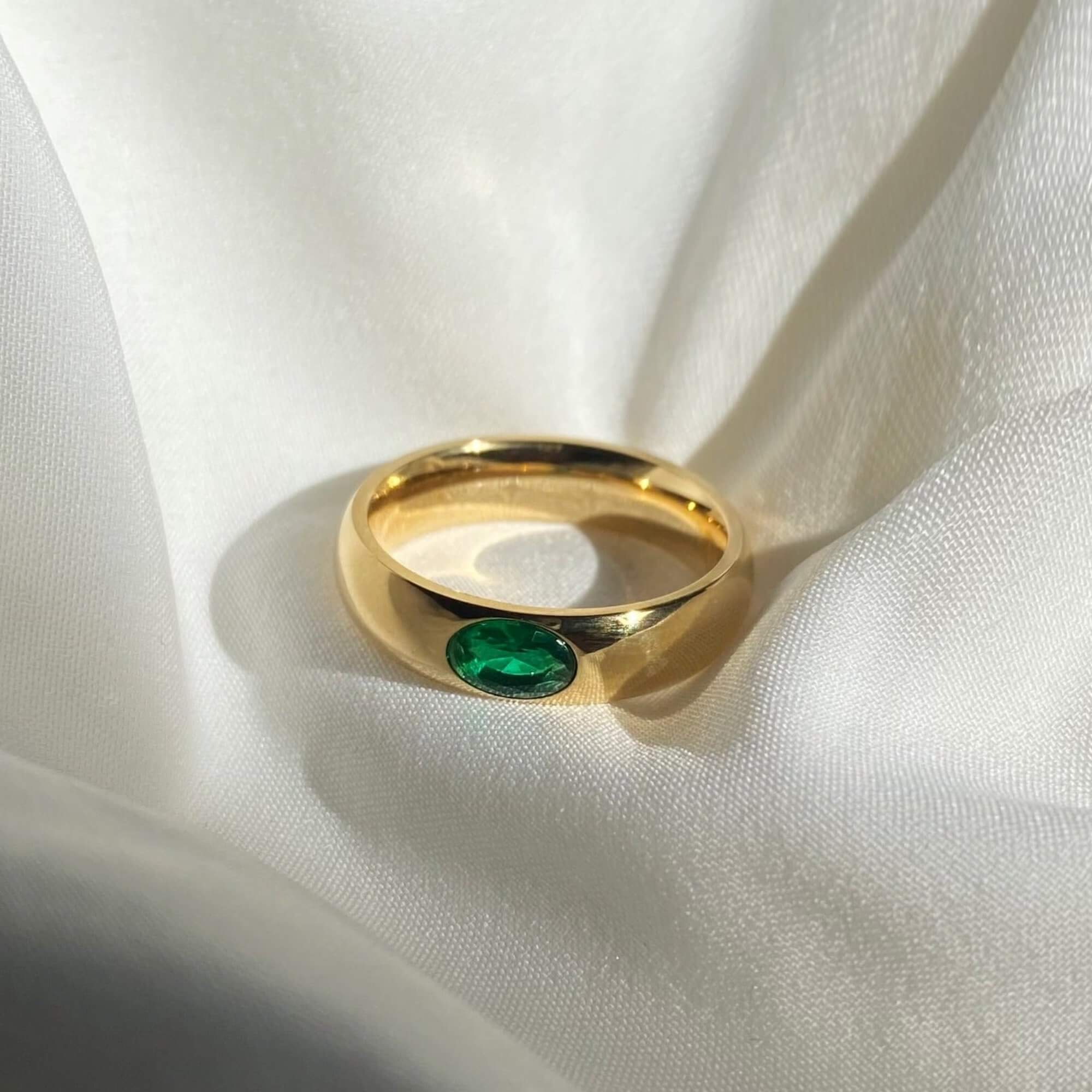 The KimmyR oval emerald cigar band ring by Kampy Designs, featuring a bold wide band and a striking oval-cut emerald gemstone.