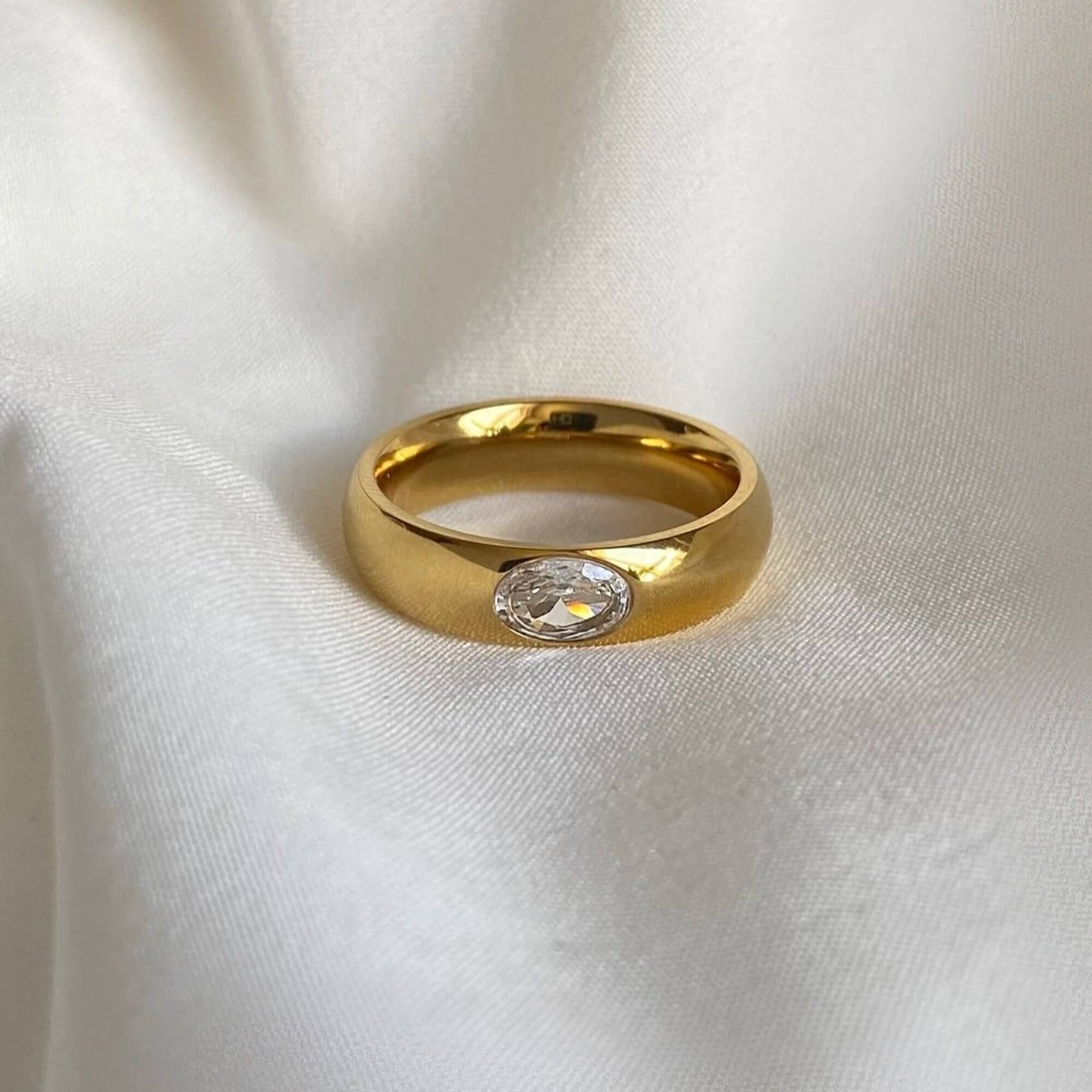 Front view of the KimmyR oval diamond cigar band ring by Kampy Designs, highlighting its oval-cut gemstone and polished wide-band setting.